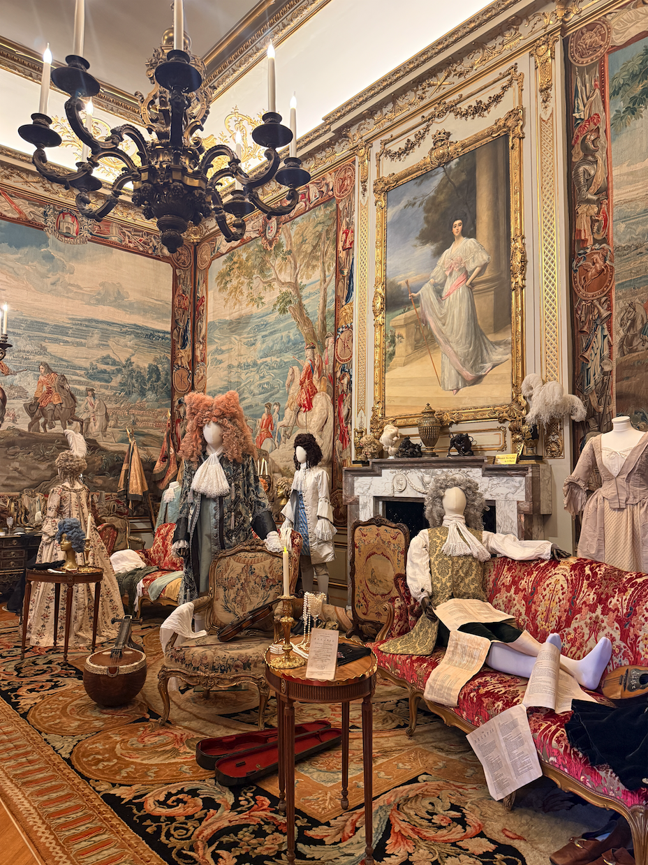 Mannequins in 18th-century period costumes and powdered wigs displayed in the ornate First State Room at Blenheim Palace, England.