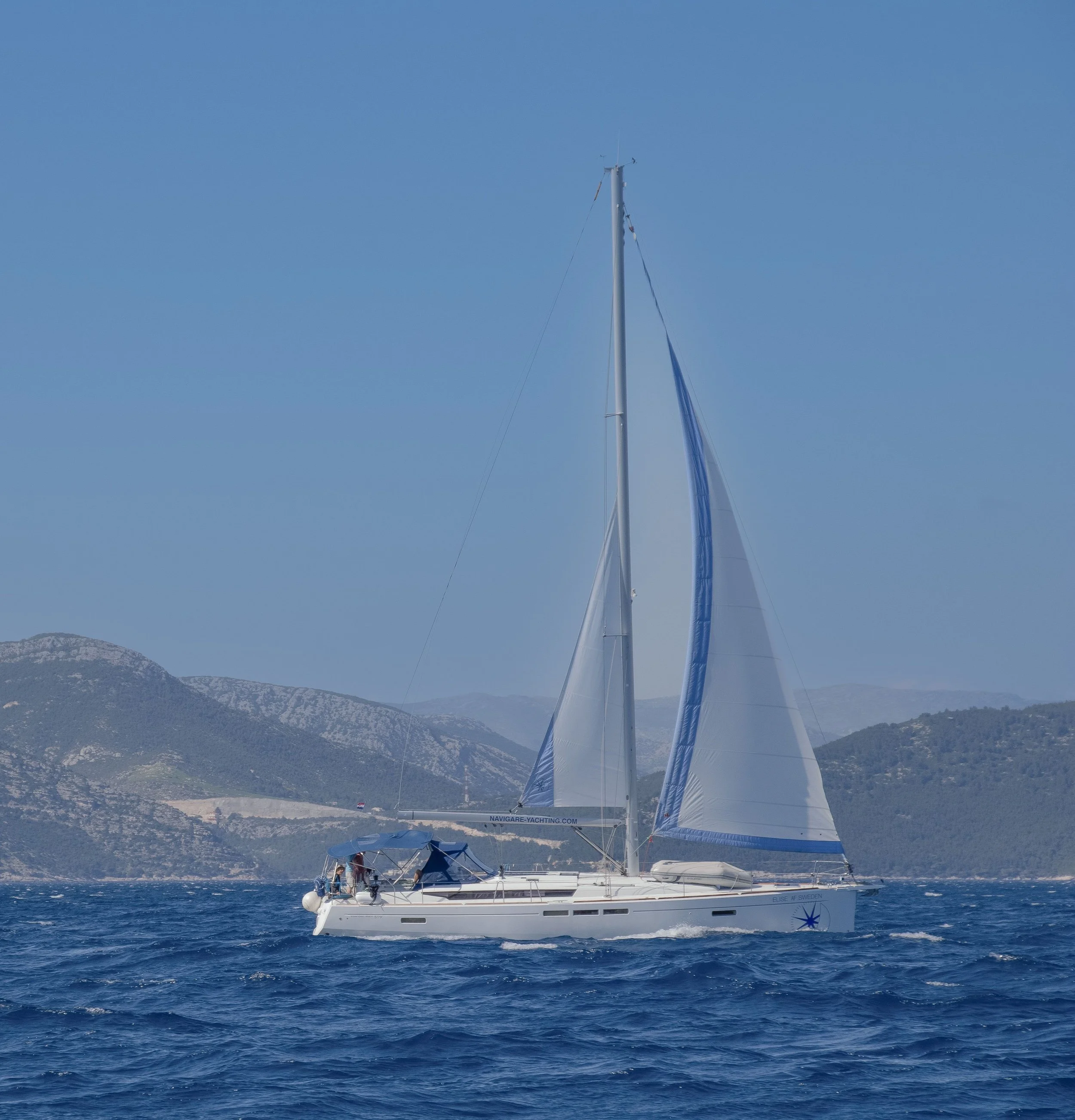 A sailboat cruising through the vibrant blue waters of Croatia’s Adriatic Sea.