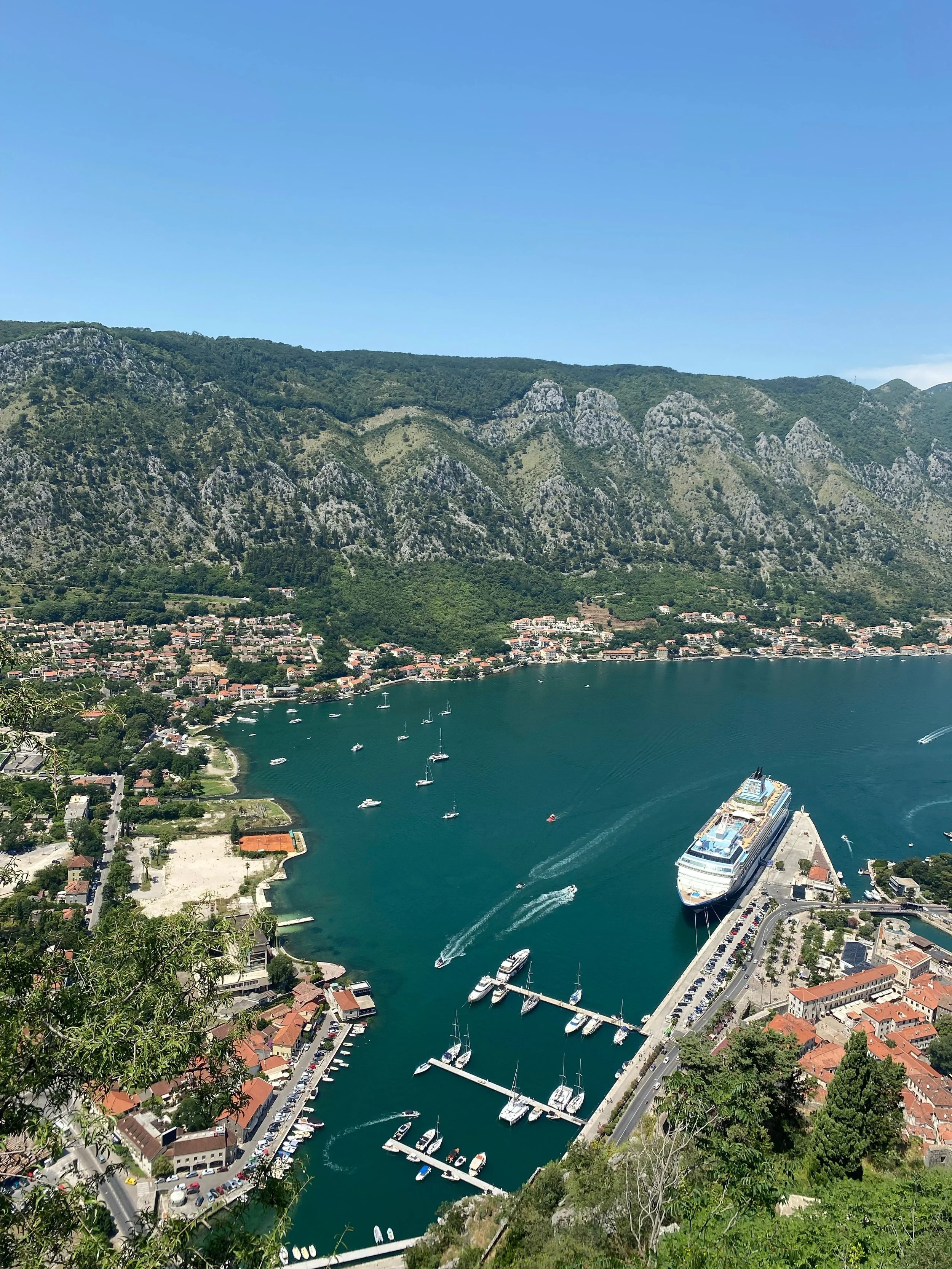 Kotor Bay, Montenegro, featuring cruise ships, the historic medieval town of Kotor, and dramatic mountains surrounding the bay.