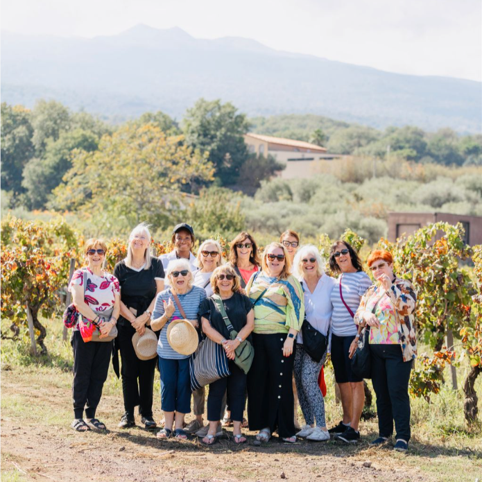 Olegana Travel Boutique women's group trip exploring a vineyard during a wine tour and tasting in Sicily, Italy.