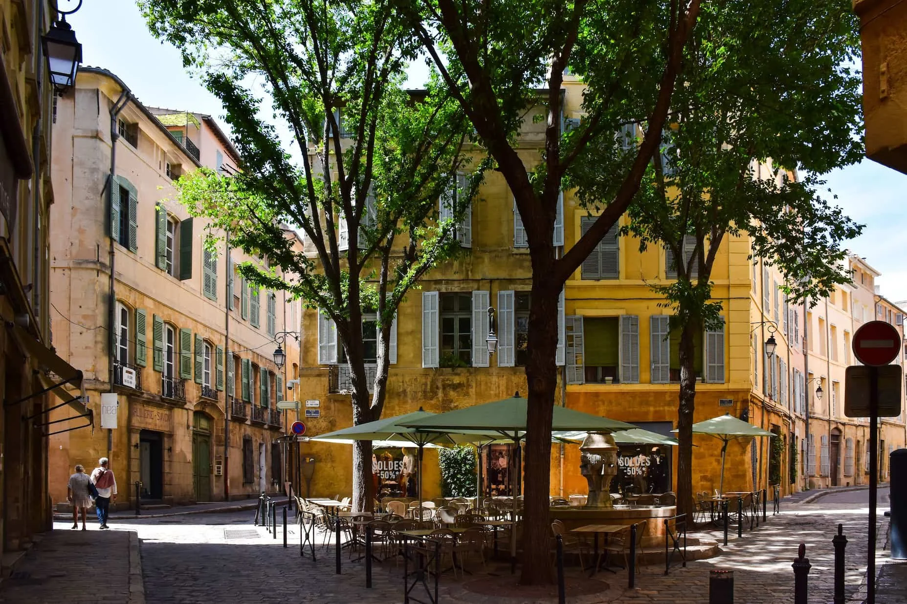 Picturesque street corner in Aix-en-Provence, France, with traditional architecture and a lively outdoor café setting.