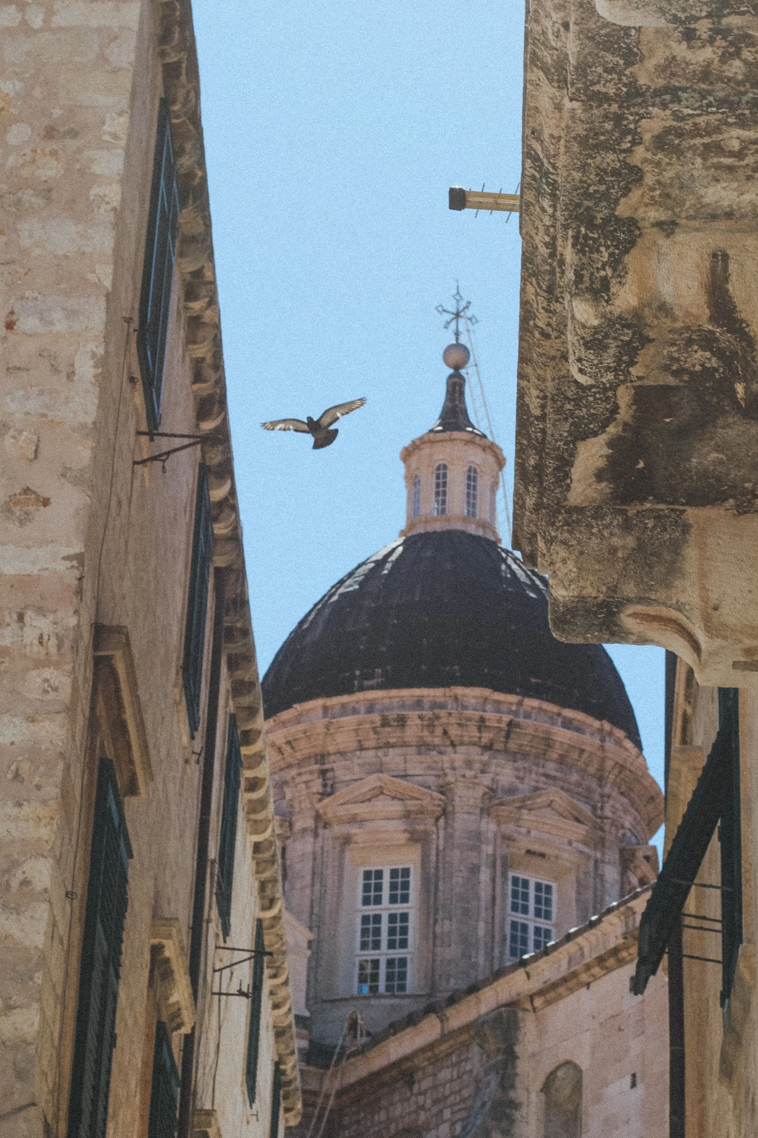 Historic church dome and surrounding architecture beneath a clear blue sky.