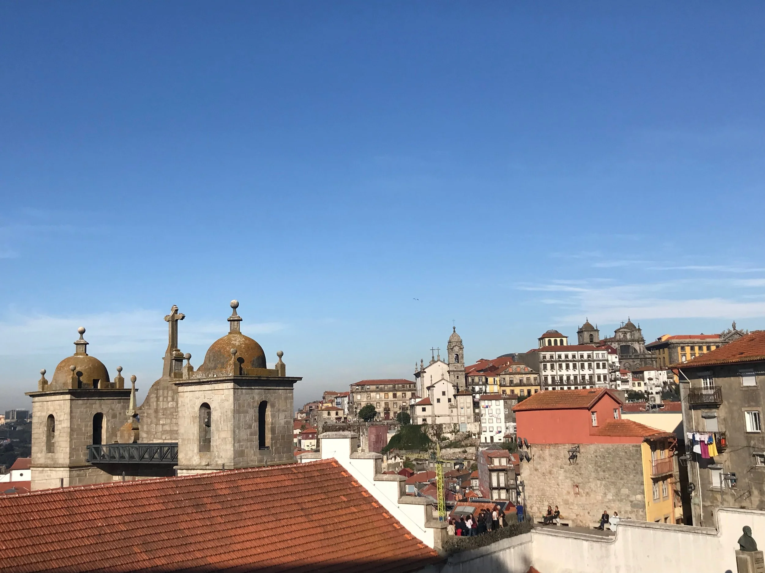 Historic rooftops of Porto, Portugal, with the Igreja dos Grilos towers and domes in the foreground.