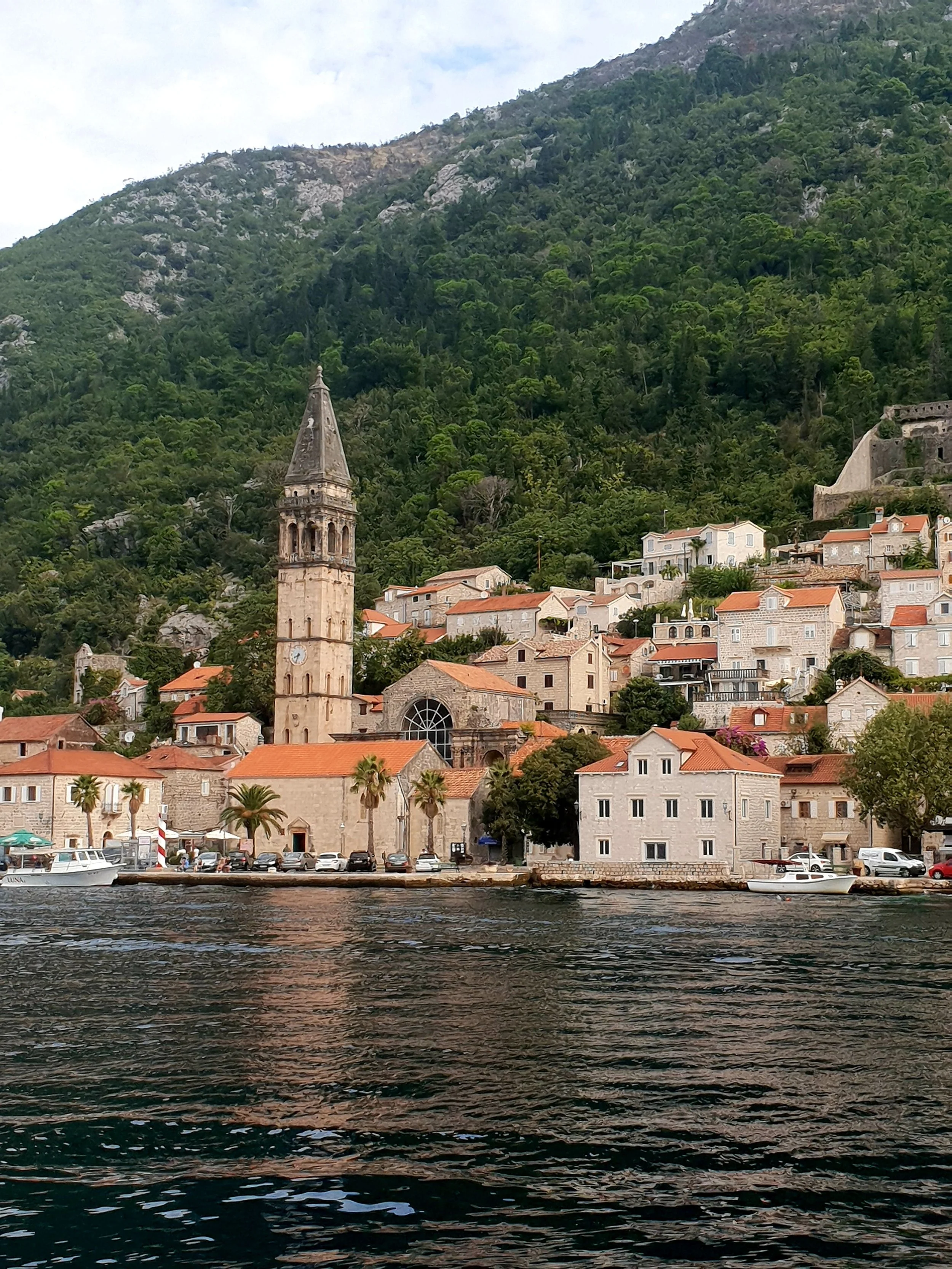 Perast, Montenegro, a picturesque historic village along the Bay of Kotor, surrounded by dramatic mountains and calm blue waters.