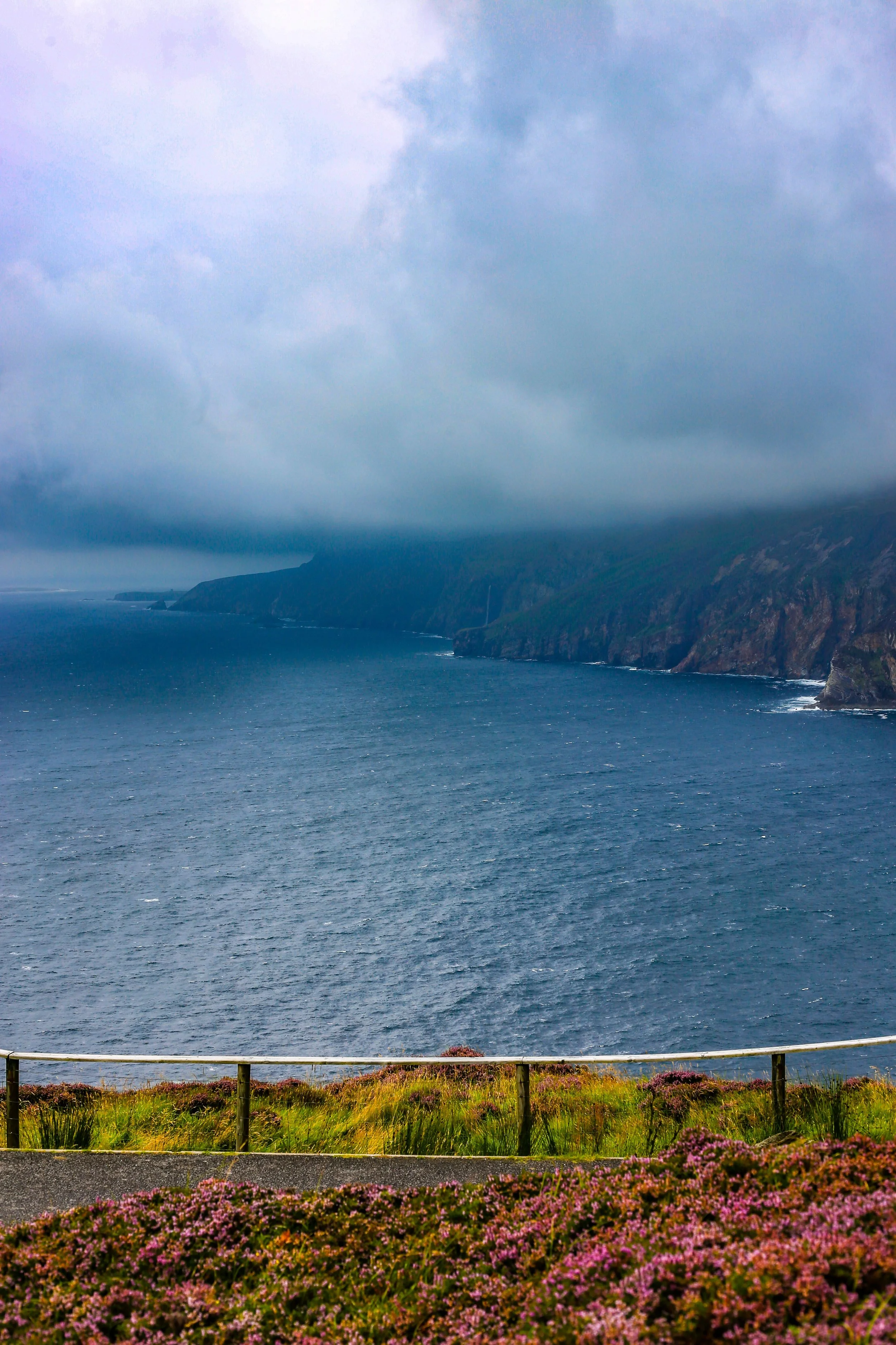 County Donegal, Ireland, featuring dramatic coastal cliffs overlooking the Atlantic Ocean beneath a cloudy sky.