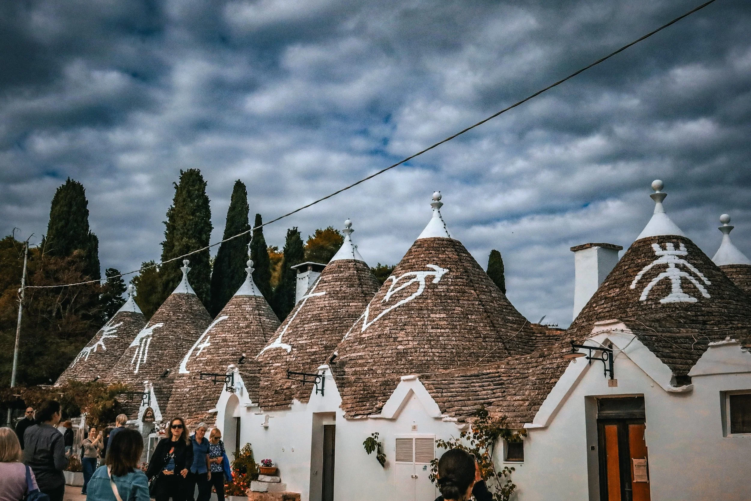 Trulli houses in Alberobello, Puglia, Italy, are traditional whitewashed stone dwellings known for their distinctive gray conical roofs and historic charm.