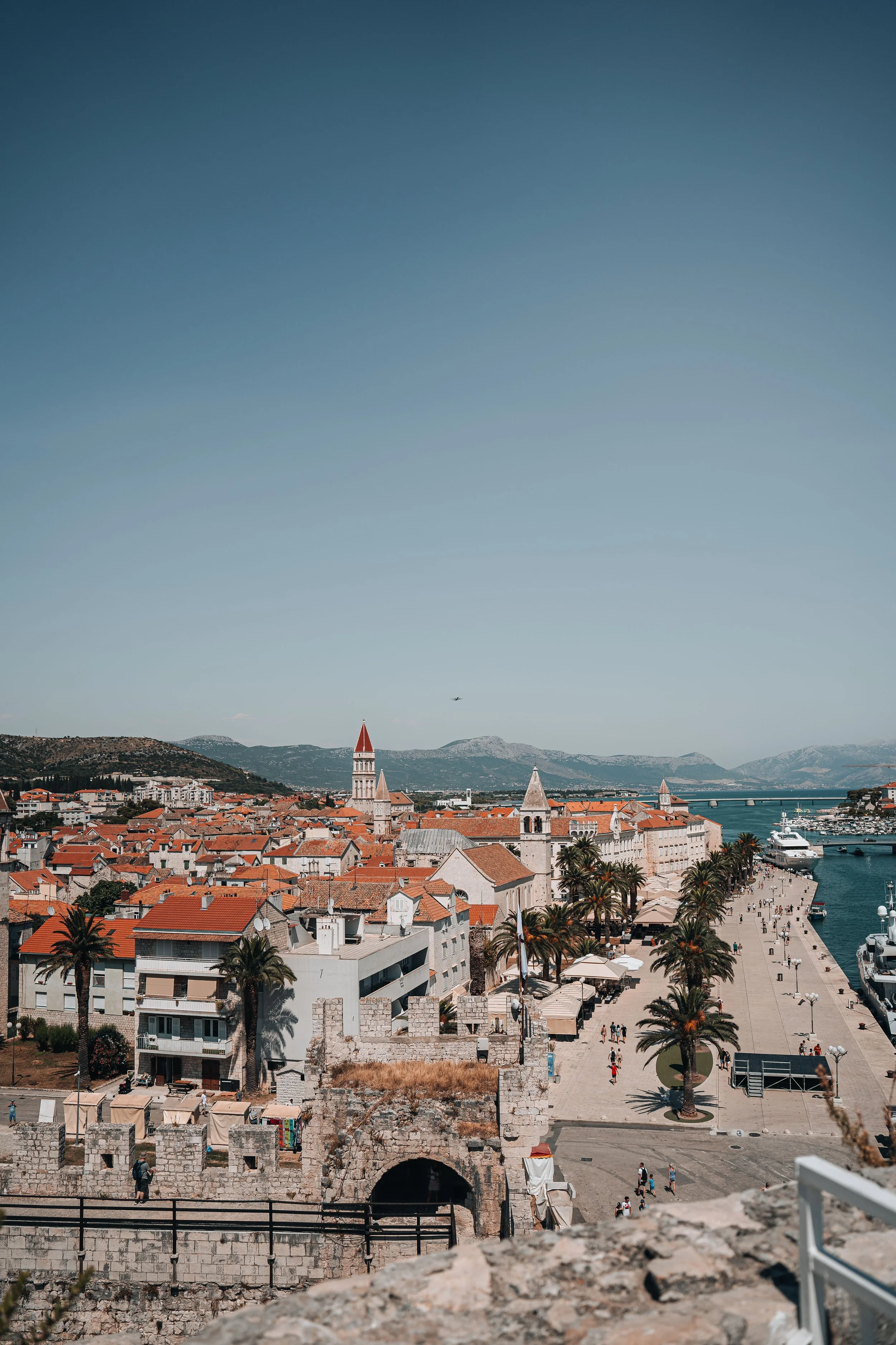 Trogir, Croatia, featuring red-tiled rooftops, historic architecture, and the Adriatic coastline.