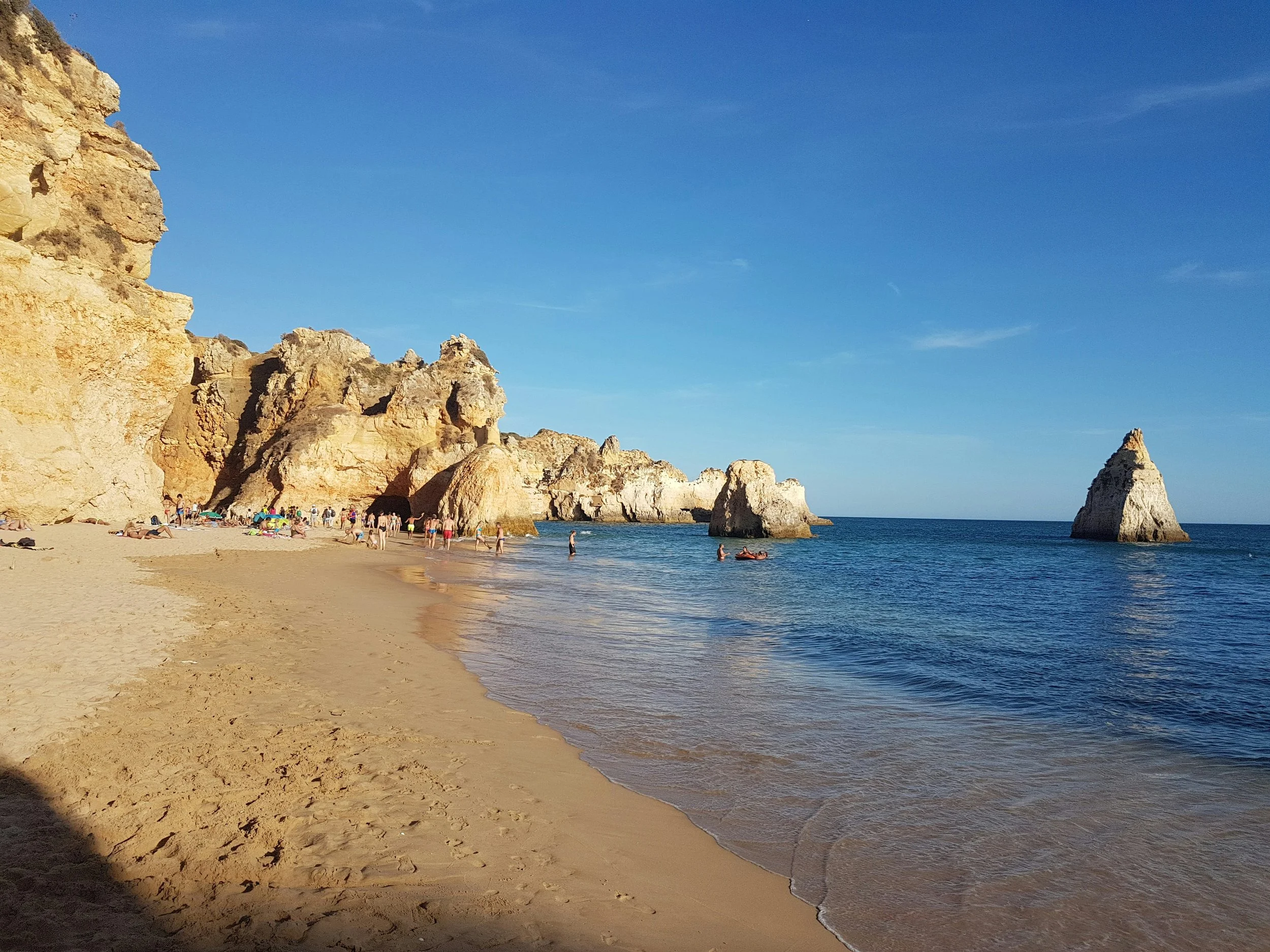 Praia dos Três Irmãos, known for its golden cliffs and clear waters in Alvor, Portugal.