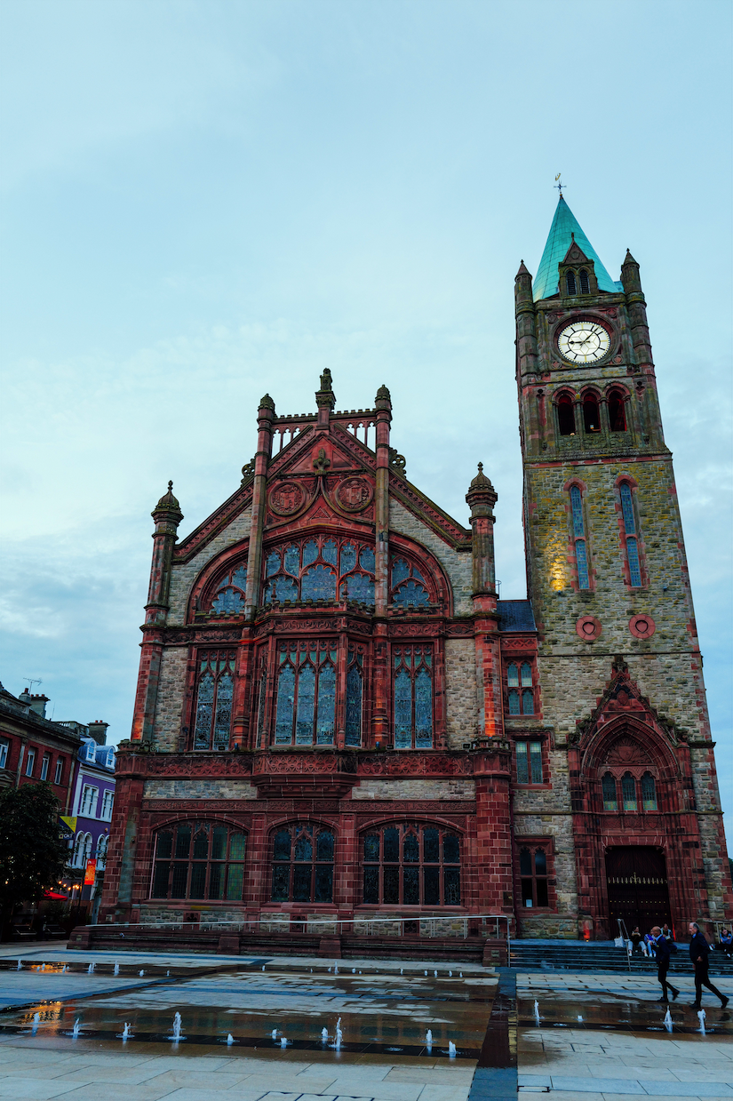The Guildhall in Derry, Northern Ireland, a striking historic building known for its red brick facade, Gothic architecture, and distinctive clock tower.