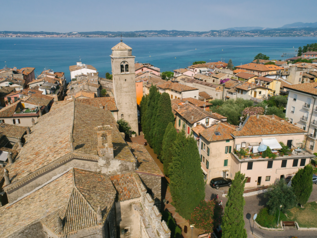 Sirmione, Lake Garda, Italy, featuring an aerial view of the historic town and Scaliger Castle surrounded by sparkling blue waters.