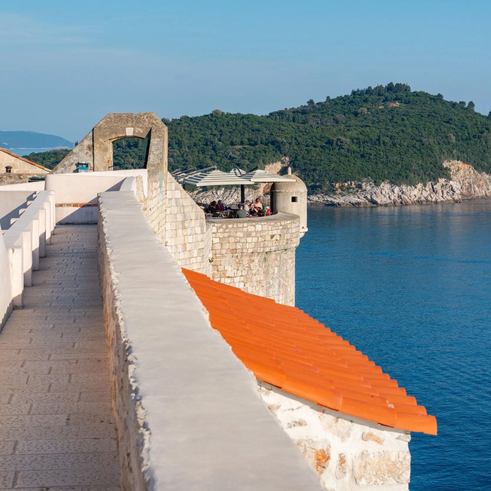 Dubrovnik, Croatia, featuring a scenic coastal path overlooking the sparkling Adriatic Sea.