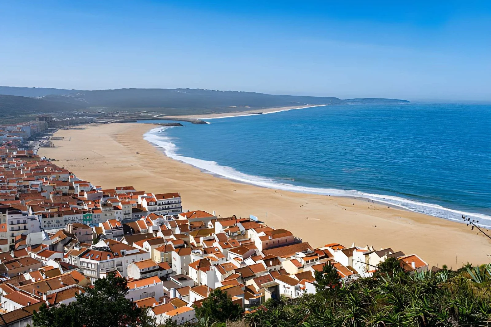 Top view of Nazaré, Portugal, with its sandy beach and dramatic coastline.