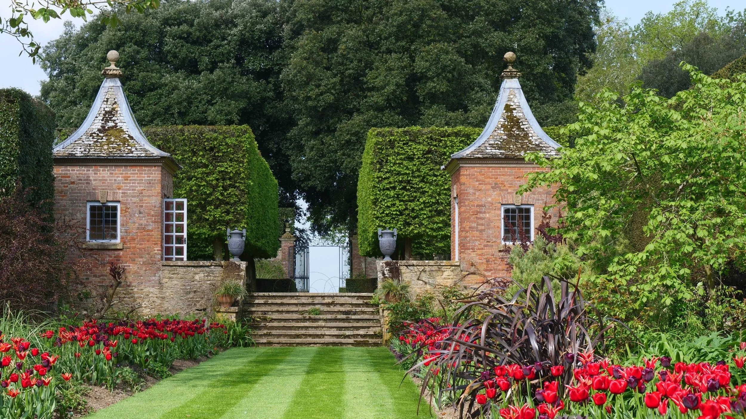 Red Borders and Gazebos at Hidcote Manor Garden, Gloucestershire, England.