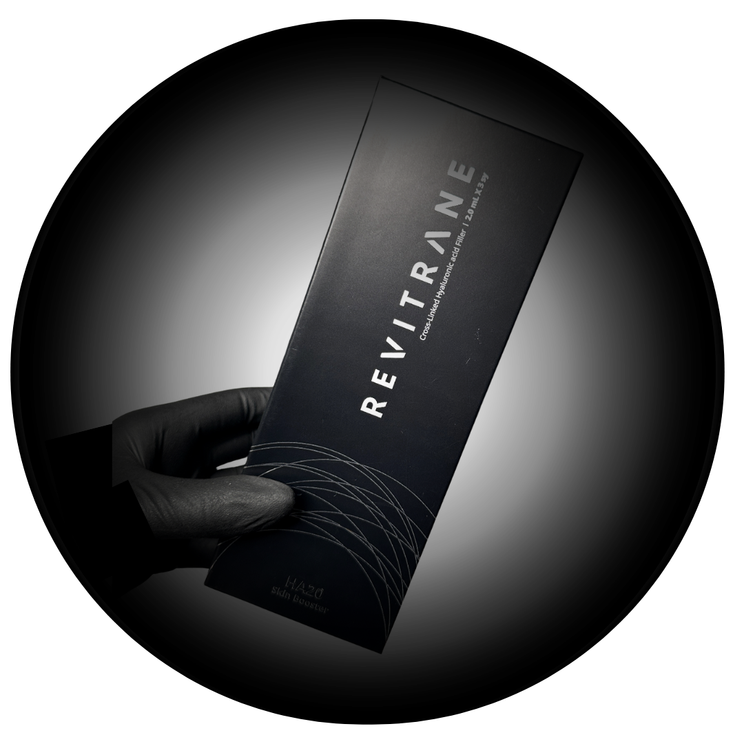 A black-gloved hand holding a black box labeled 'REVITRINE,' indicating a cross-linked hyaluronic acid filler product.