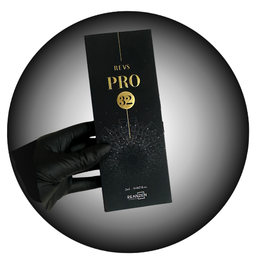 A hand wearing a black glove holding a black box labeled "REVS PRO 32" with a geometric web design and technical text, against a black background.