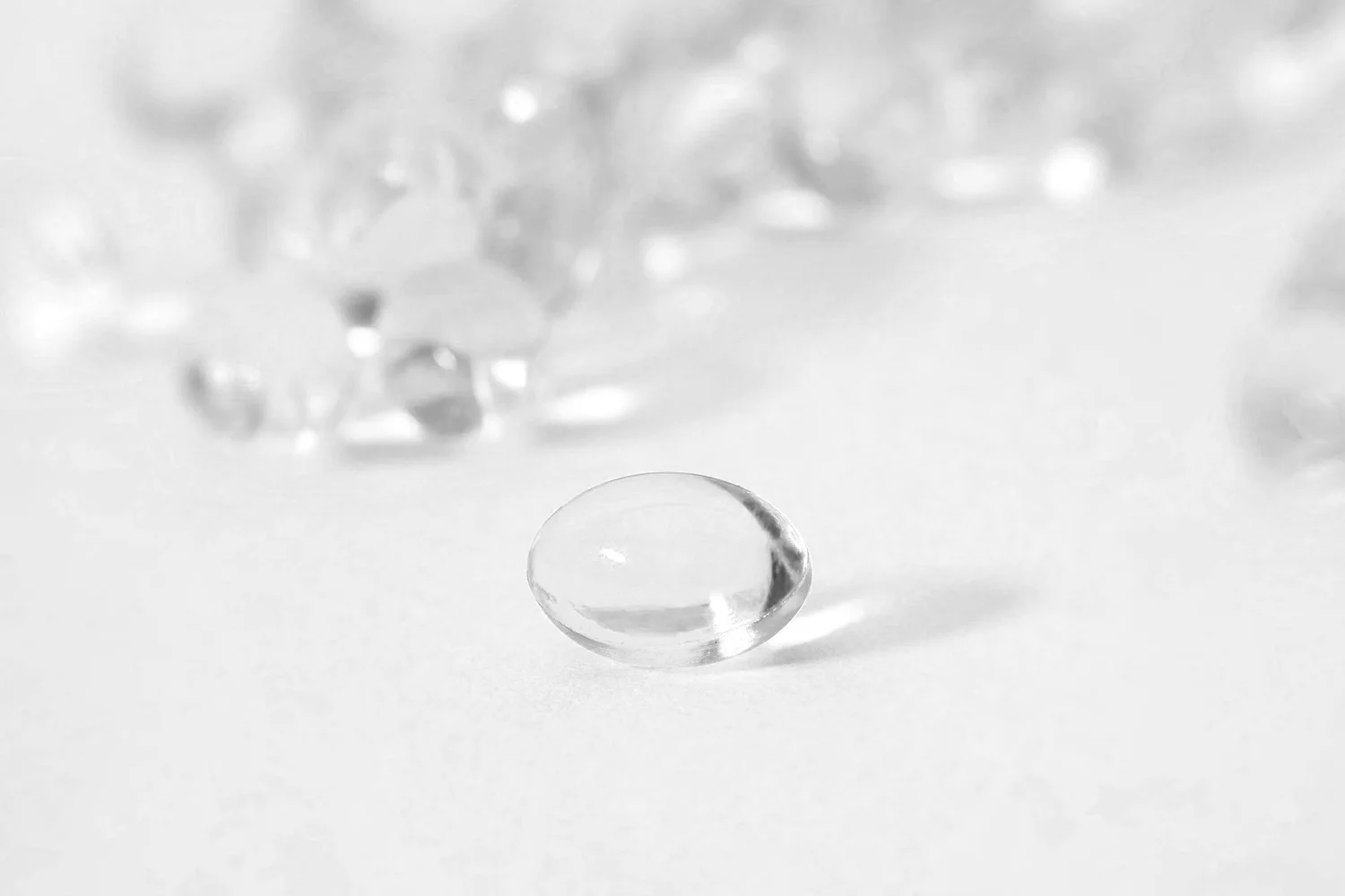 Clear softgel supplements on a white surface