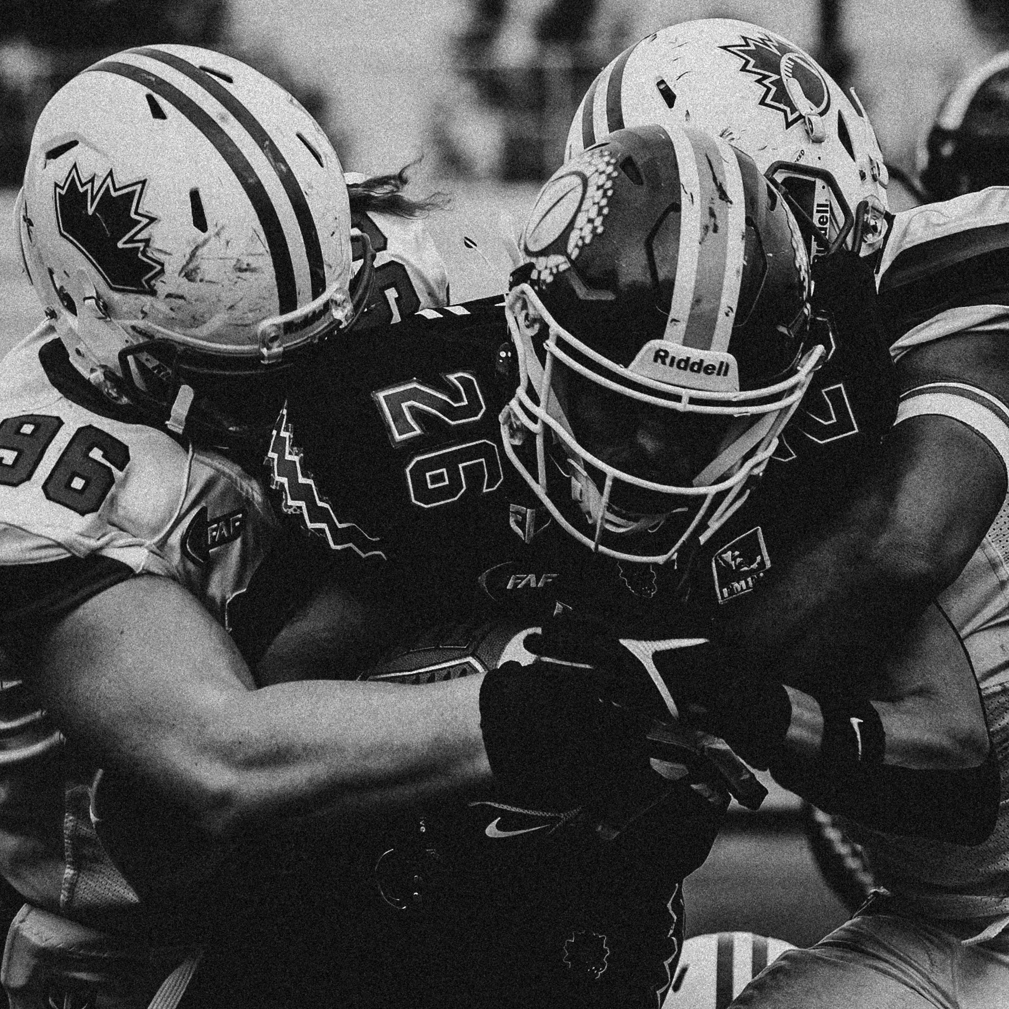 Two football players in action, wearing helmets and uniforms, competing during a game.