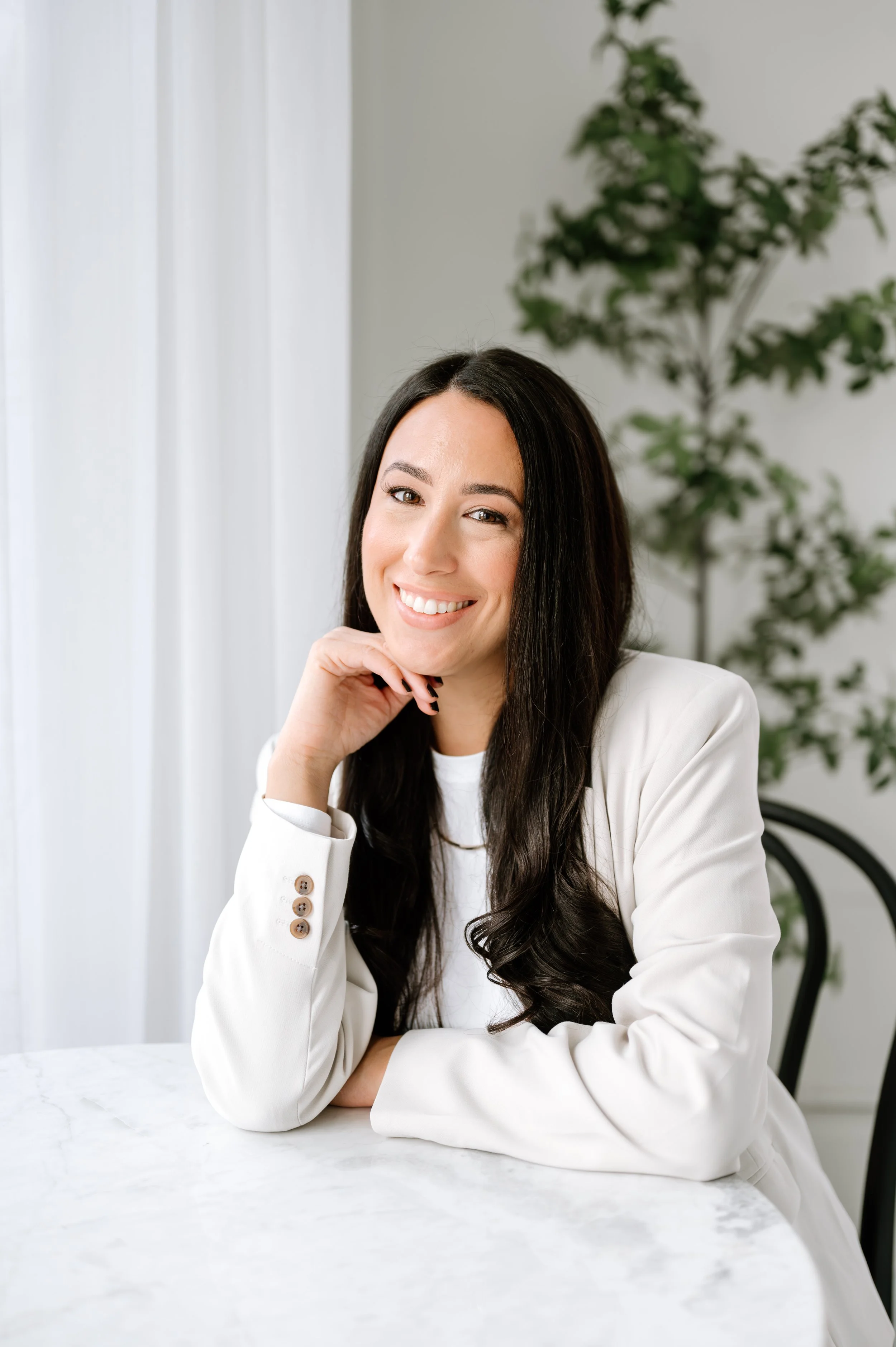 Elisa Russo, owner of Aligned Marketing Studio, smiling in a calm, minimal workspace, representing intentional and organized marketing support.
