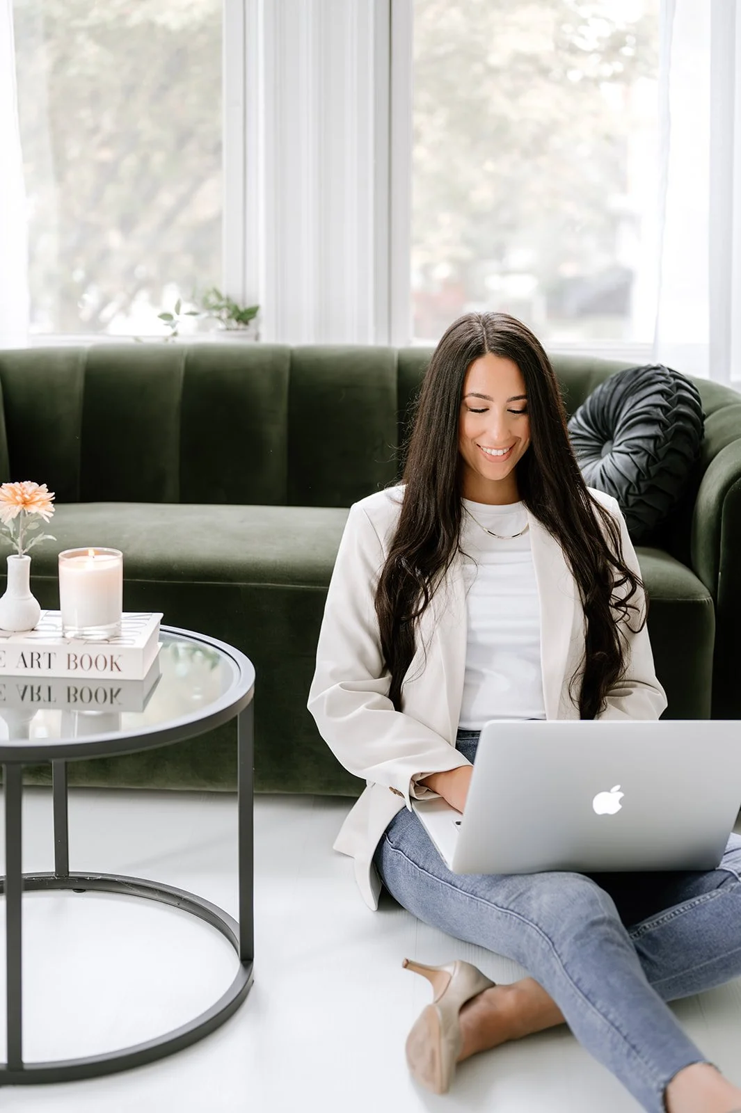 Marketing studio owner sitting with a laptop in a calm, minimal space, representing clear, intentional marketing support.