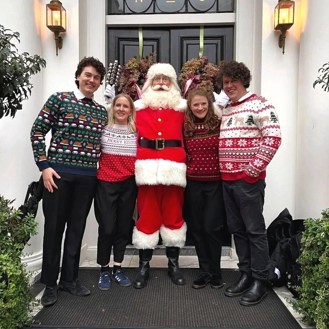 The London Christmas Carollers, a professional Christmas carol-singing quartet in festive jumpers and Santa hats, available to hire for Christmas events in London.