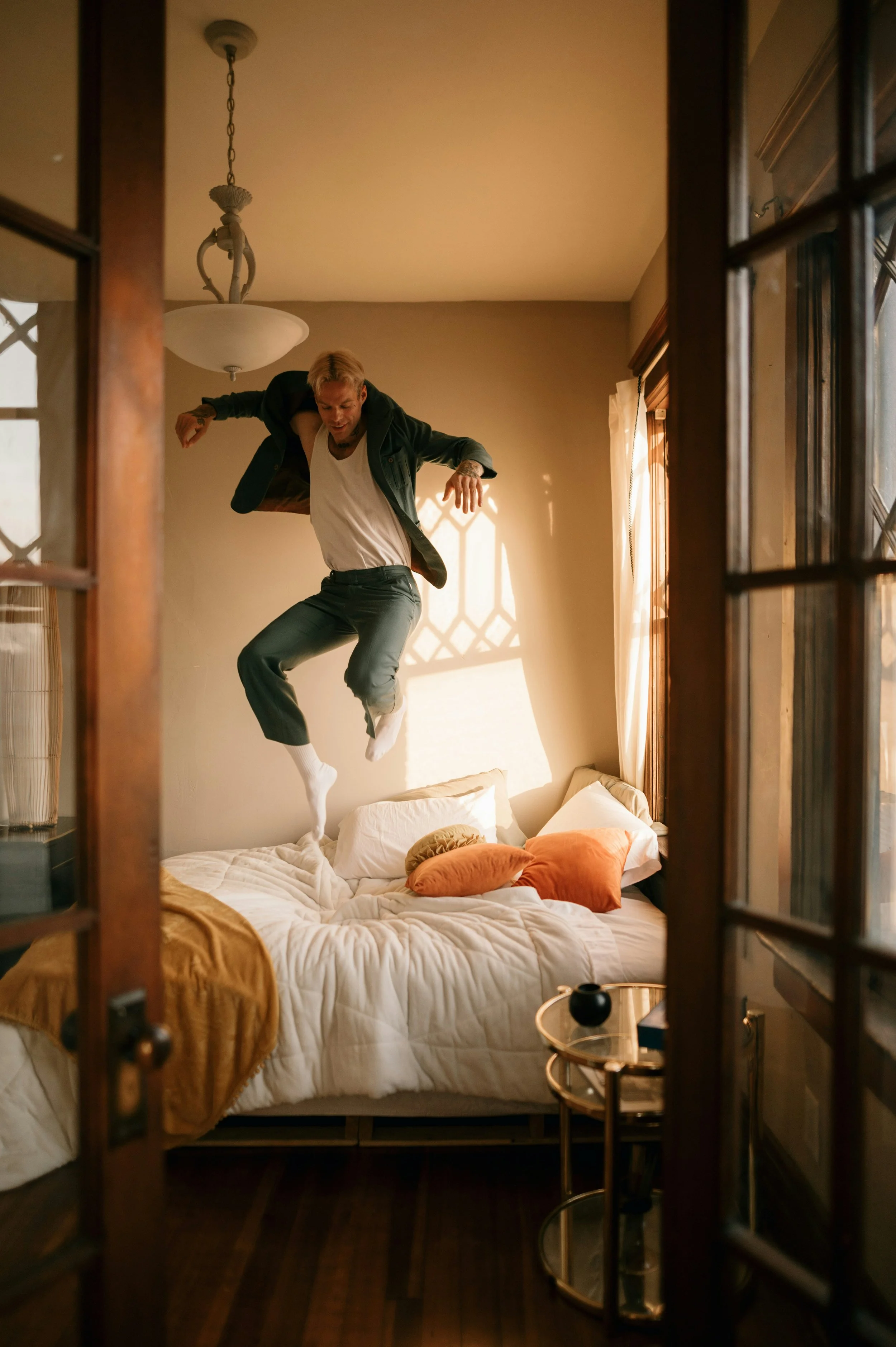 Photo of man jumping on his bed