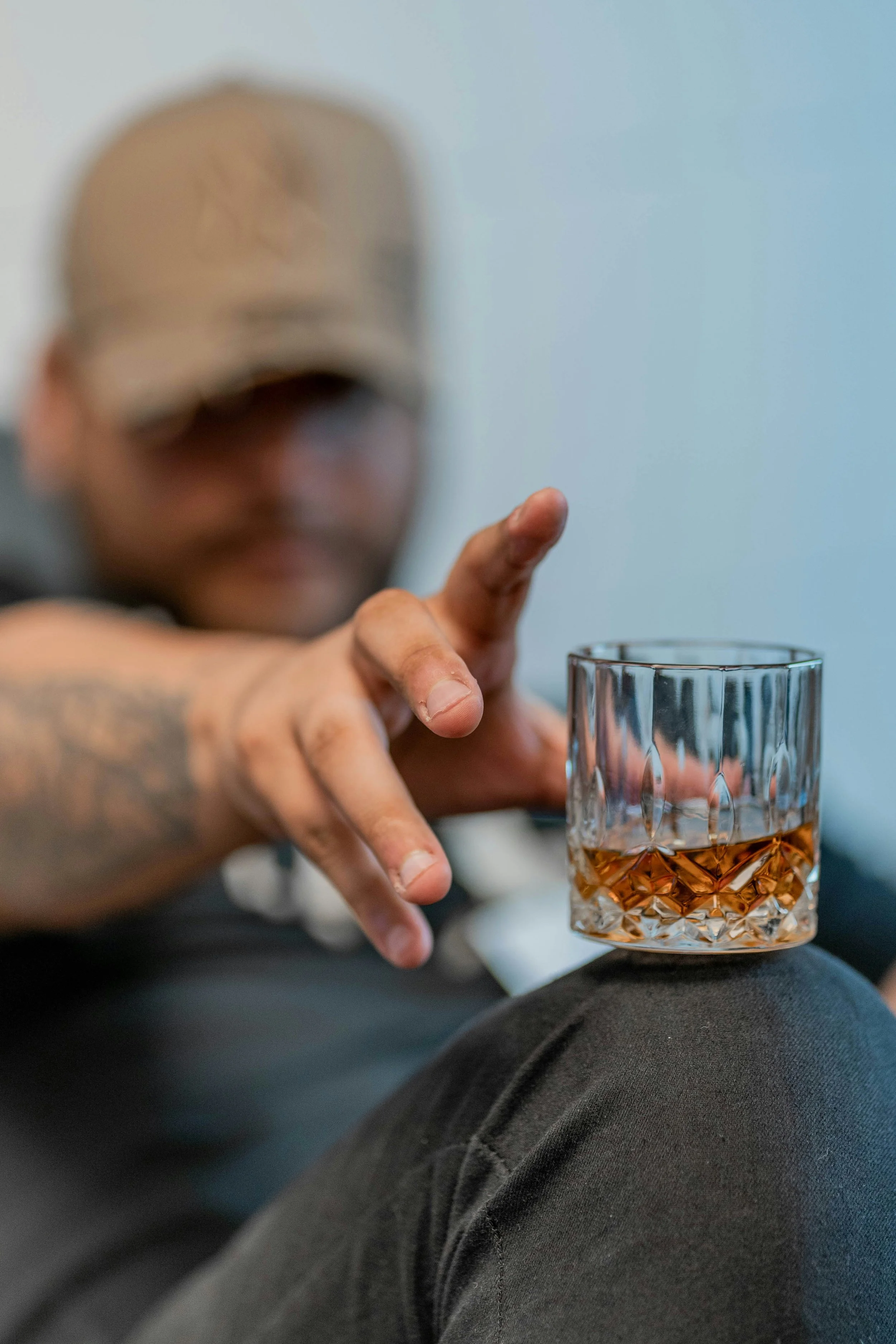 Photo of man reaching for a highball glass