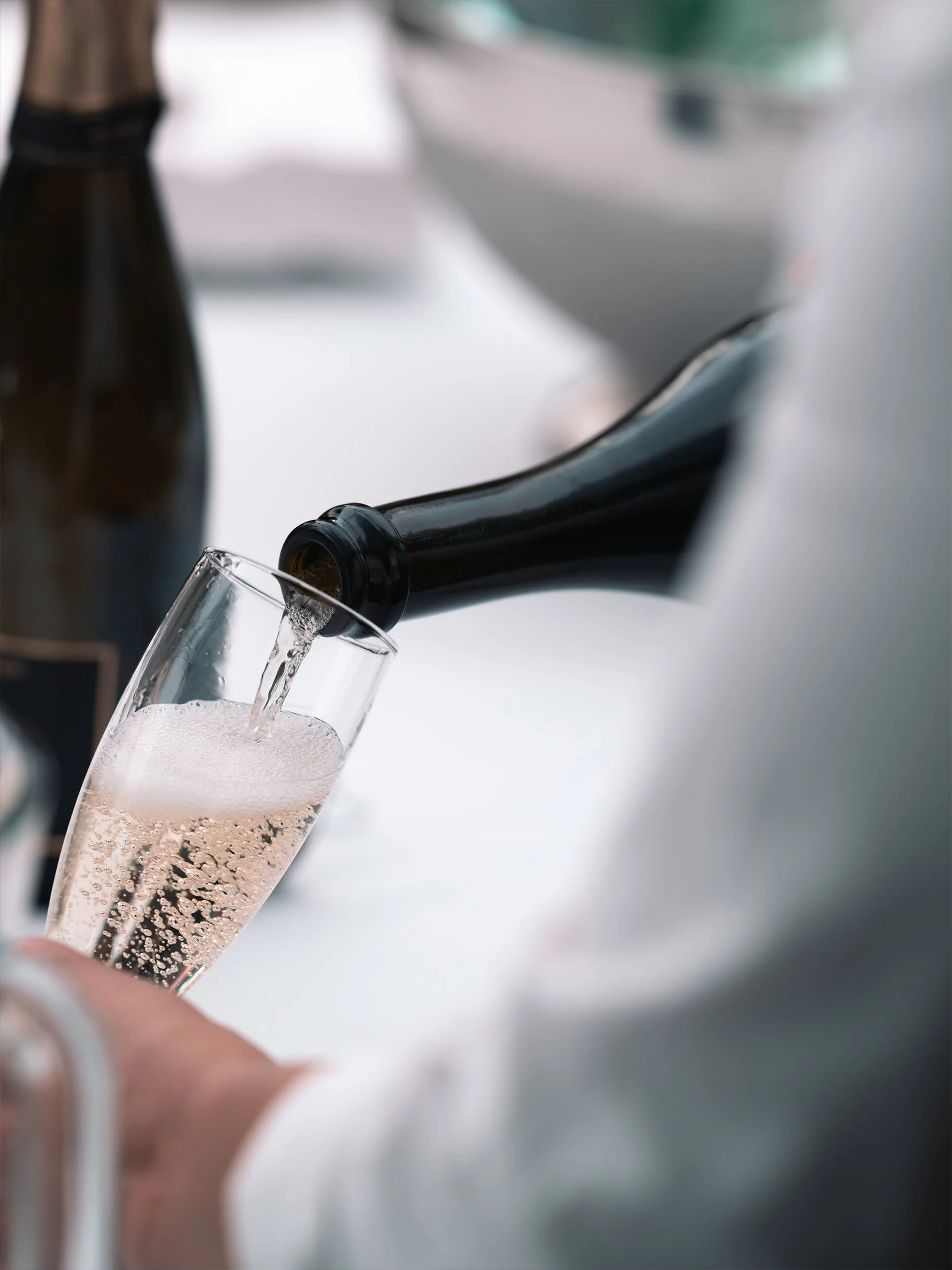 Crémant wird mit feiner Perlage in ein Sektglas eingeschenkt.
