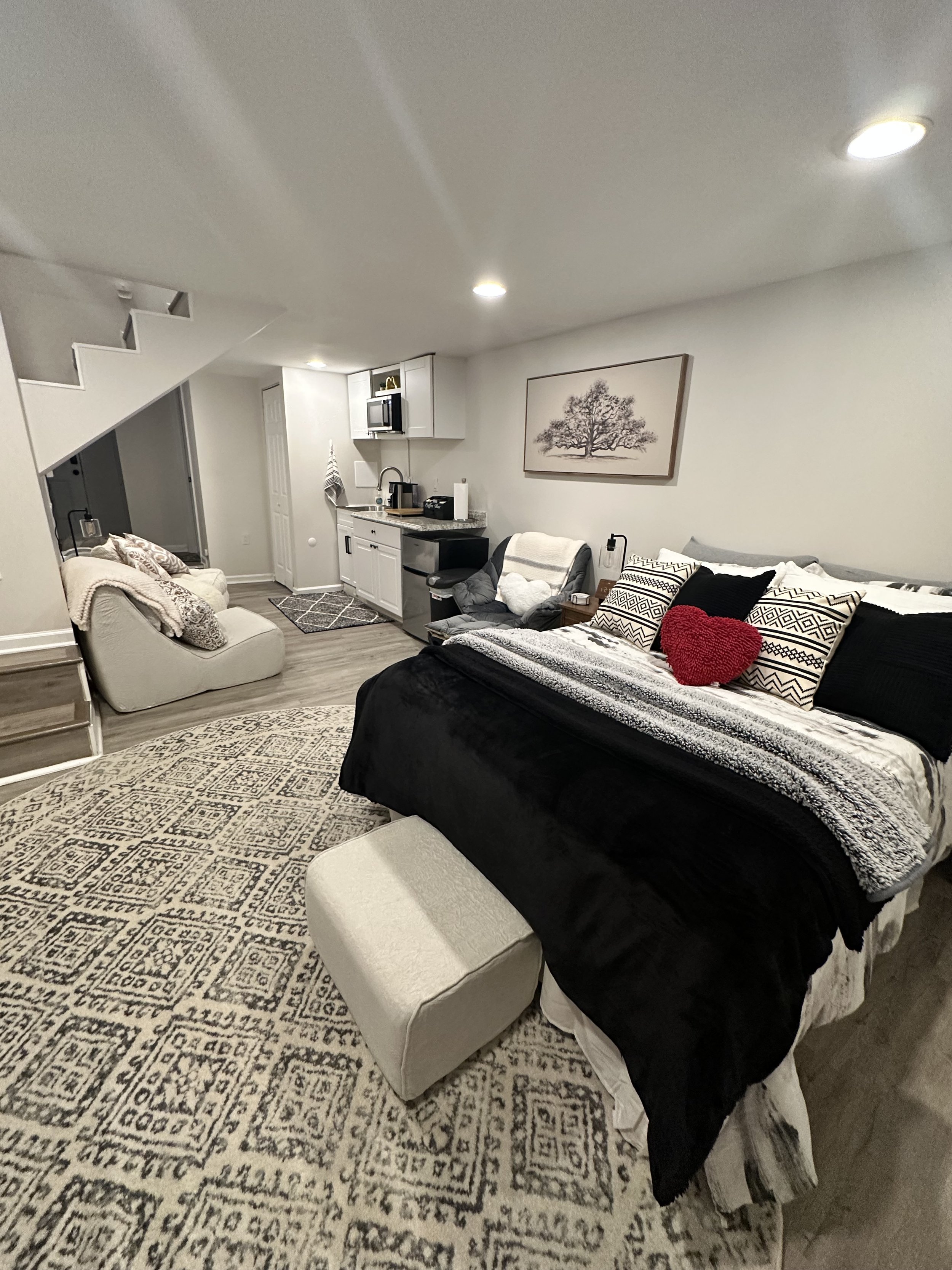Basement Suite – A private oasis featuring a queen-size bed, flat-screen TV, coffee station, microwave, and additional lounge seating for extra comfort and privacy.