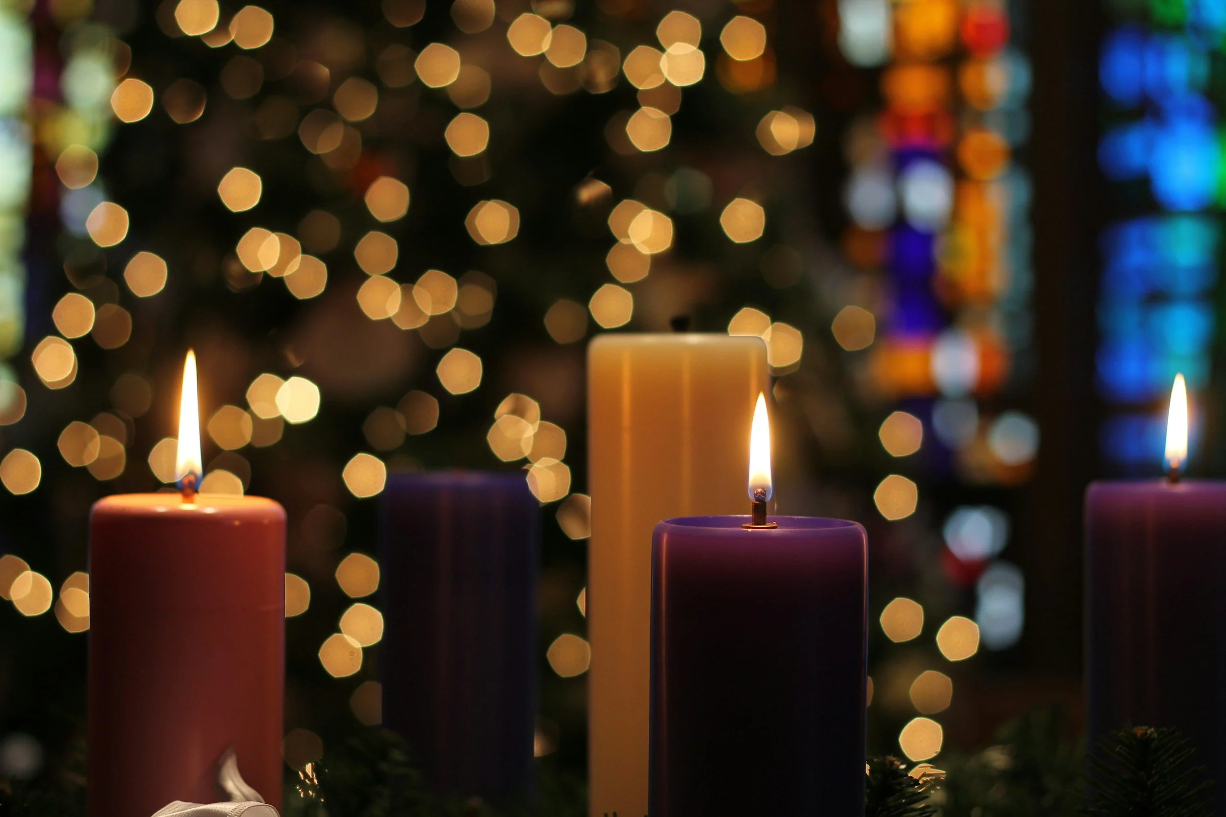 burning candles in front of Christmas tree