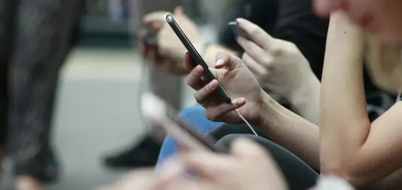 people's hands using their cell phones