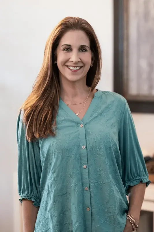 Abbie standing looking at camera in green shirt