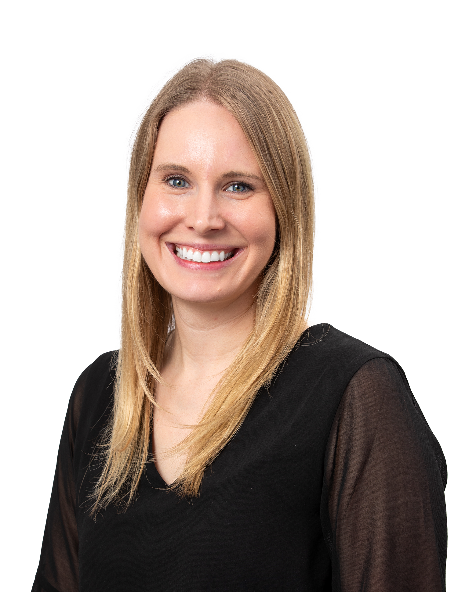 A smiling woman with straight blonde hair, wearing a black top with sheer sleeves, posing against a light gray background.