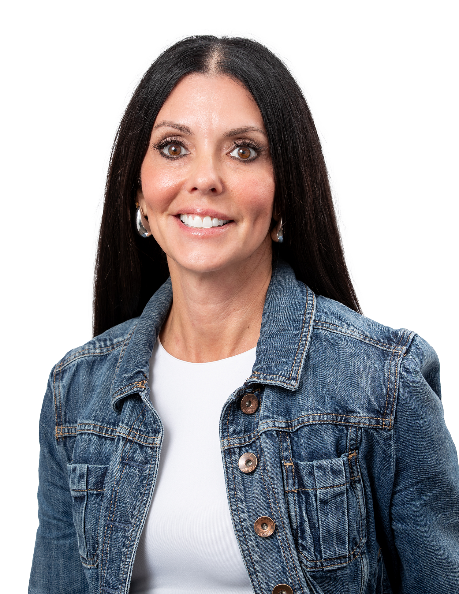 A woman with long dark hair, wearing a denim jacket over a white top, smiling and looking at the camera.
