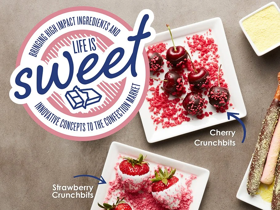 Plate of cherry crunchbites with chocolate coating and pink sprinkles, and strawberries with strawberry crunchbites, on gray background with logo and text about sweet ingredients.