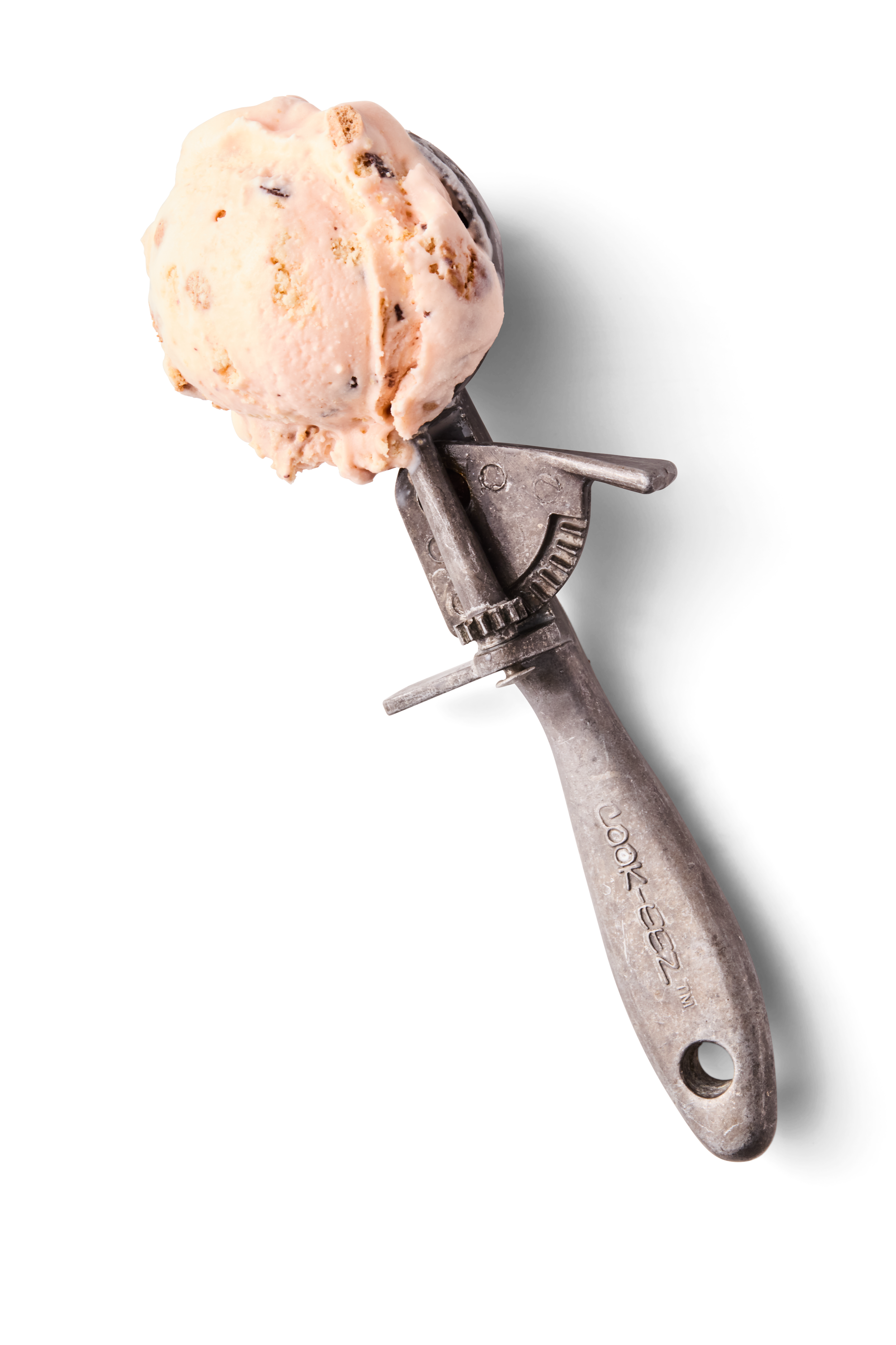 A scoop of vanilla ice cream with chocolate chips on a vintage ice cream scooper against a black background.