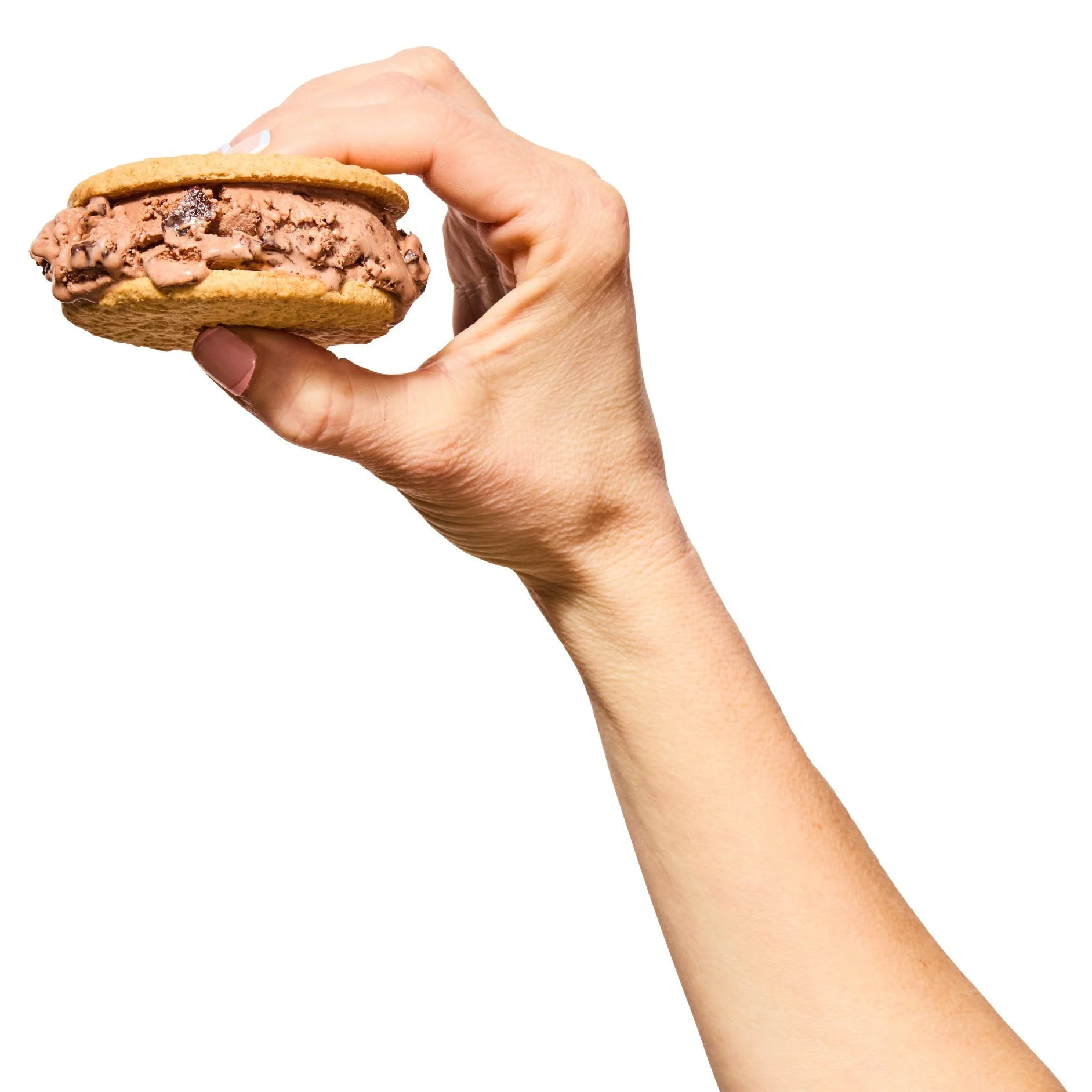 Hand holding a chocolate chip ice cream sandwich with vanilla cookie wafers