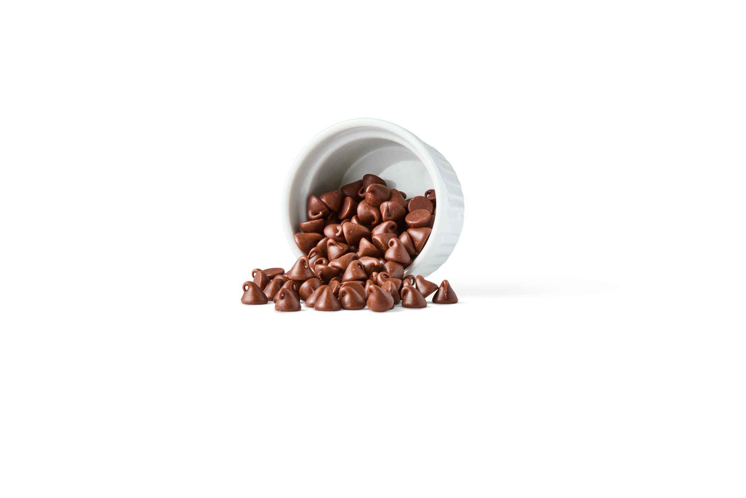 Chocolate chips spilling out of a white container on a black background.