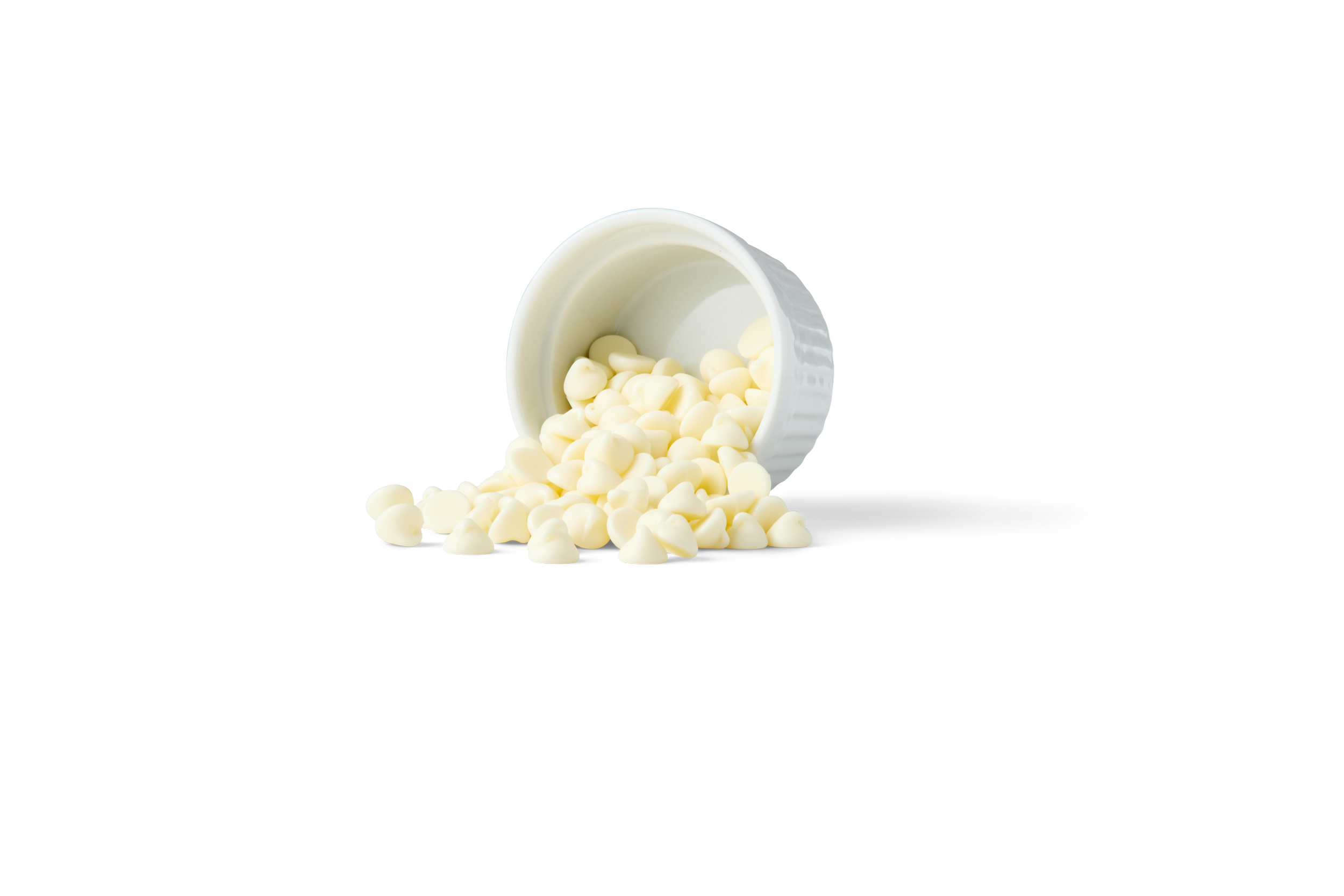 White chocolate chips spilled from a white container, with a black and white striped background.