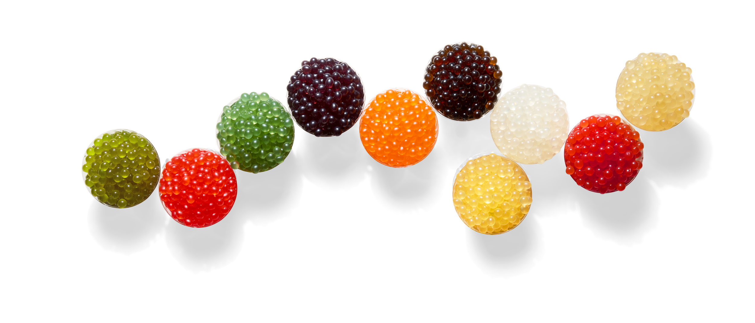 Colorful popping boba pearls in various colors including green, red, black, orange, white, yellow, and red.