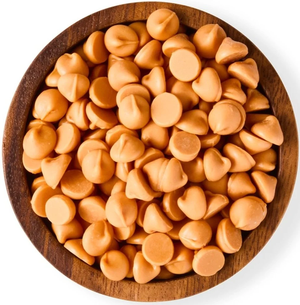 A wooden bowl filled with beige butterscotch candies.