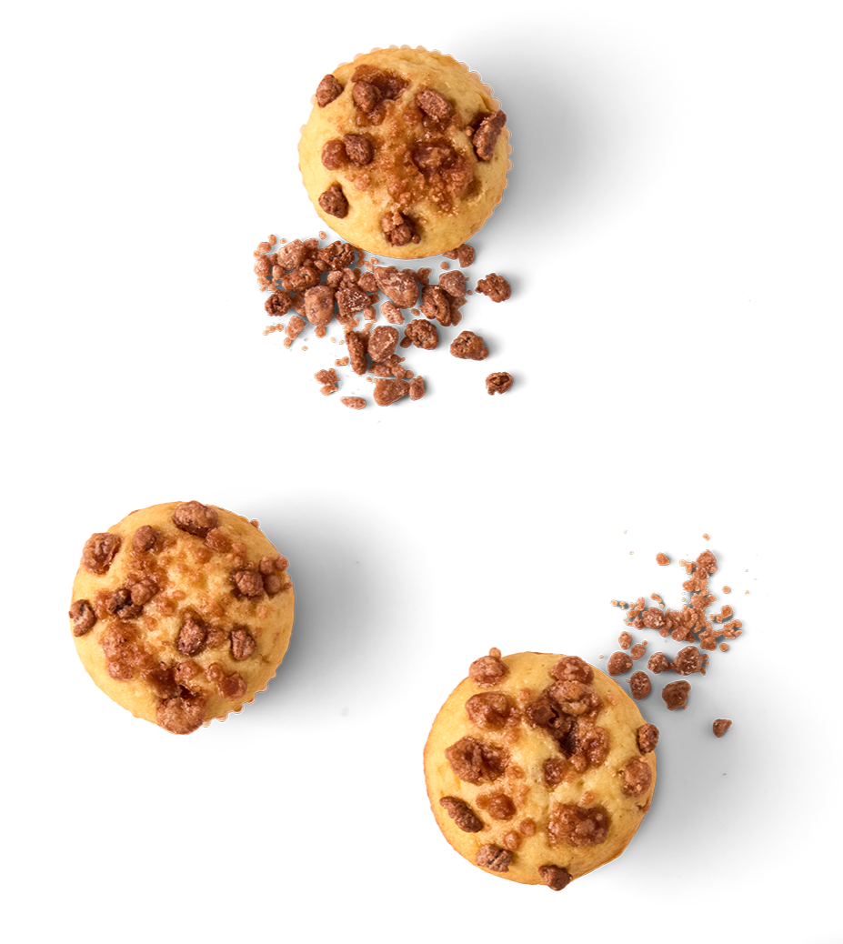 Three chocolate chip cookies with some crumbs scattered around, viewed from above.
