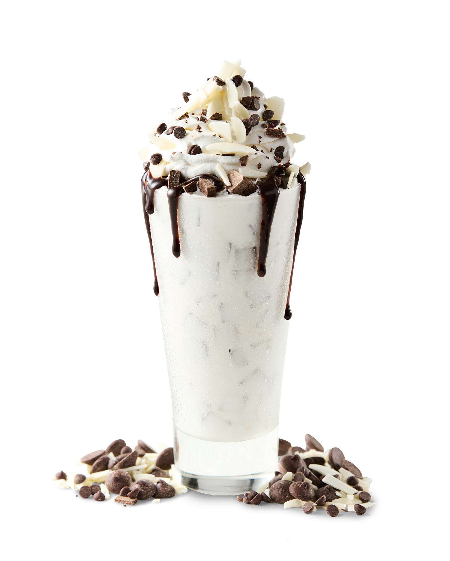 A tall glass of cookies and cream milkshake topped with whipped cream, chocolate shavings, and chocolate syrup, with scattered chocolates around the base.