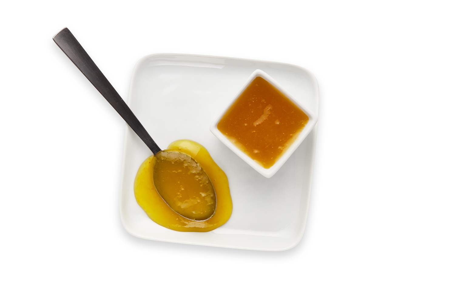 White square plate with a teaspoon of yellow sauce, a small white bowl of brown sauce, and a yellow pepper.