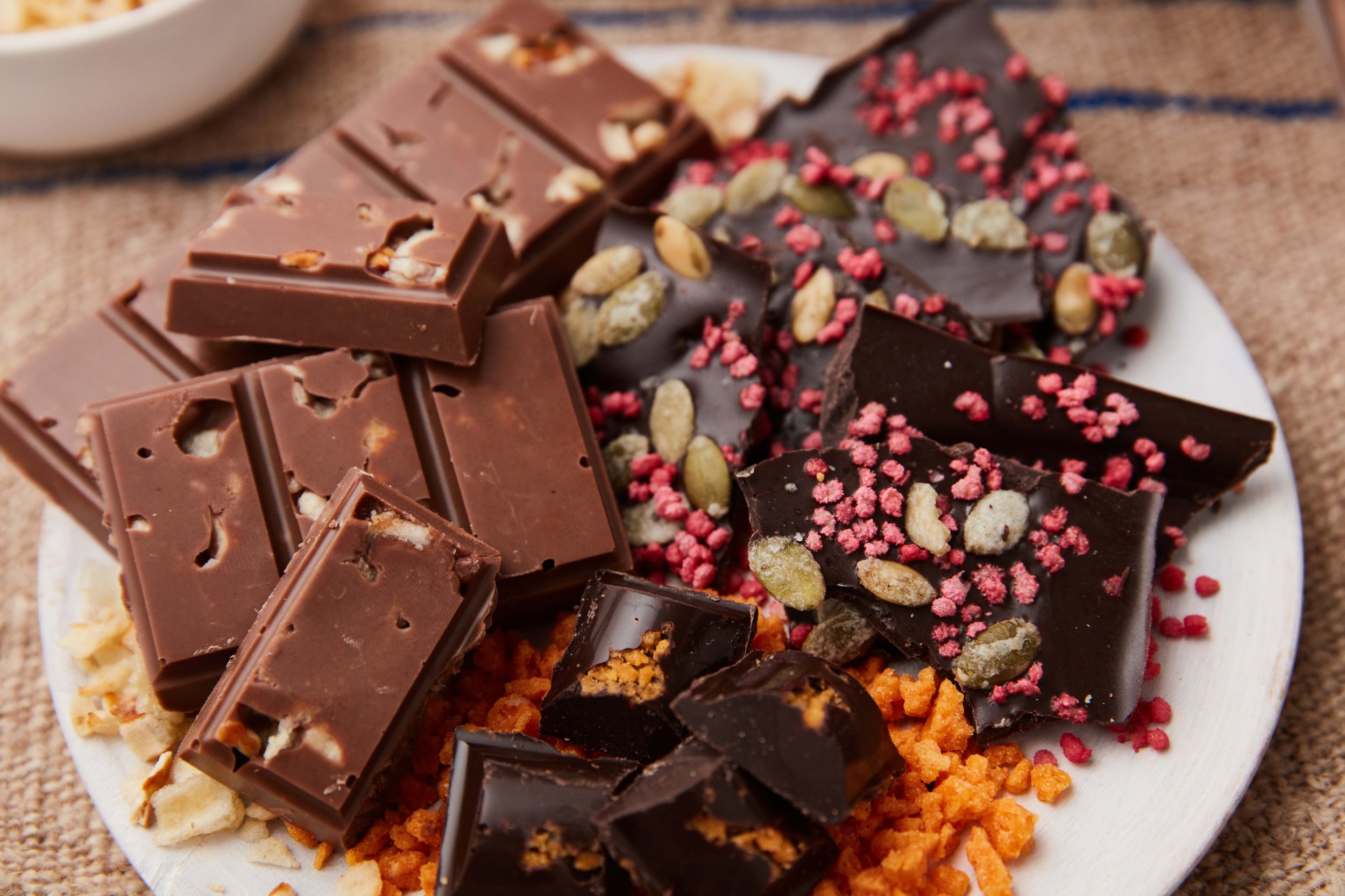 Assorted chocolates with various toppings on a white plate.