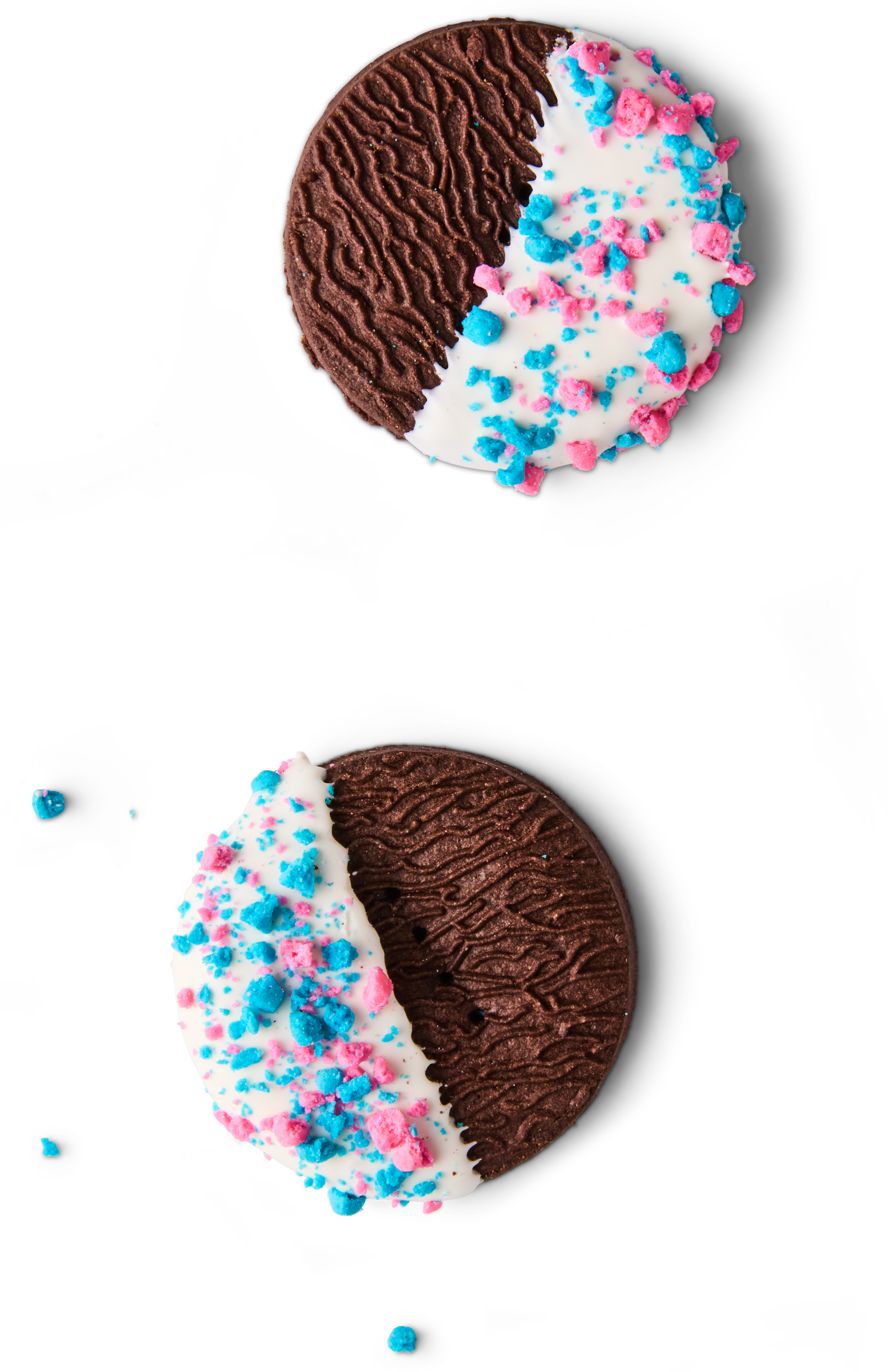 A round Oreo cookie split in half, with one half dipped in white chocolate and decorated with pink and blue sprinkles, on a black background.