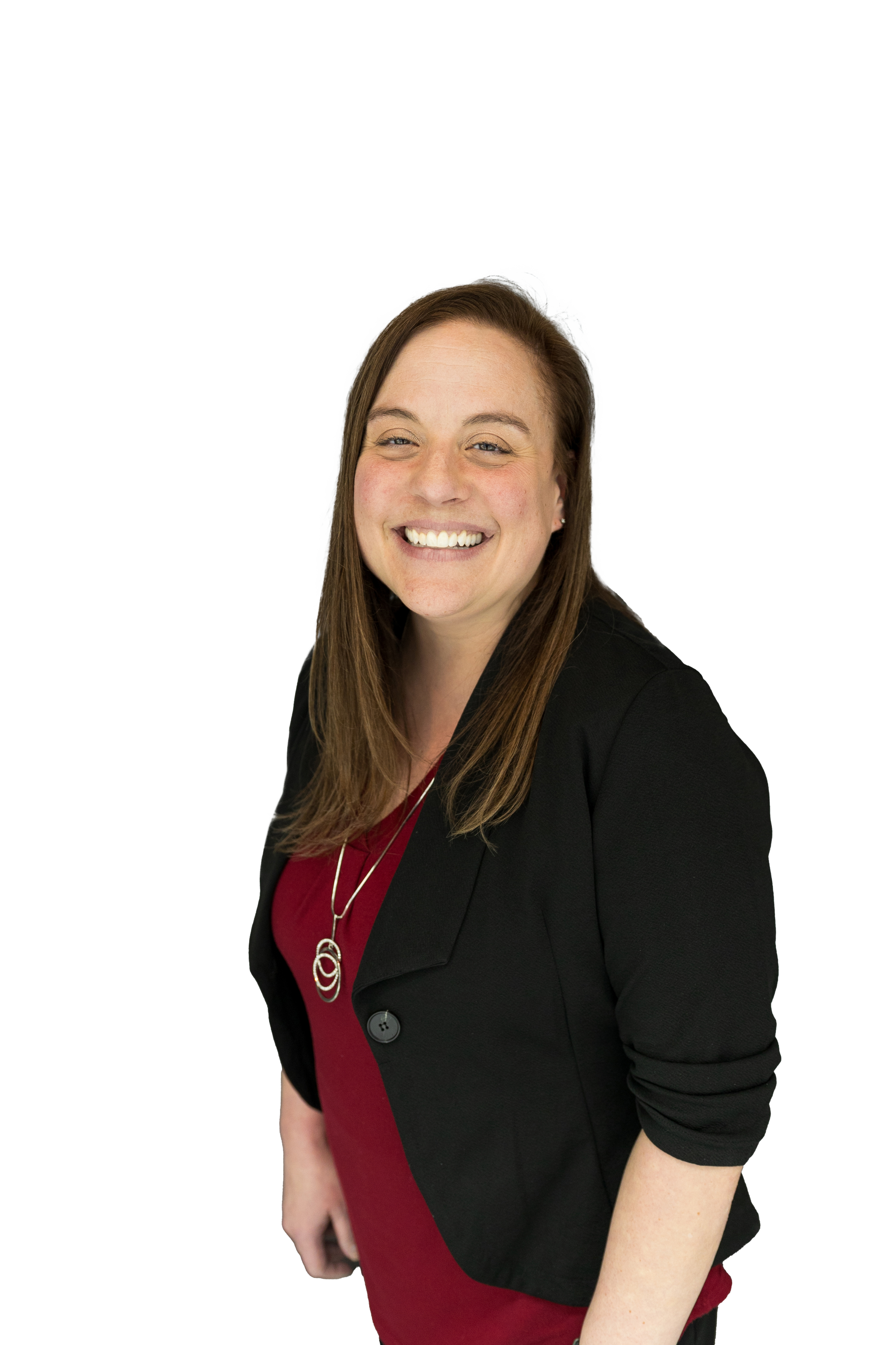 Portrait of a smiling woman with long brown hair, wearing a black blazer over a dark red dress, accessorized with a silver necklace, standing against a white background.
