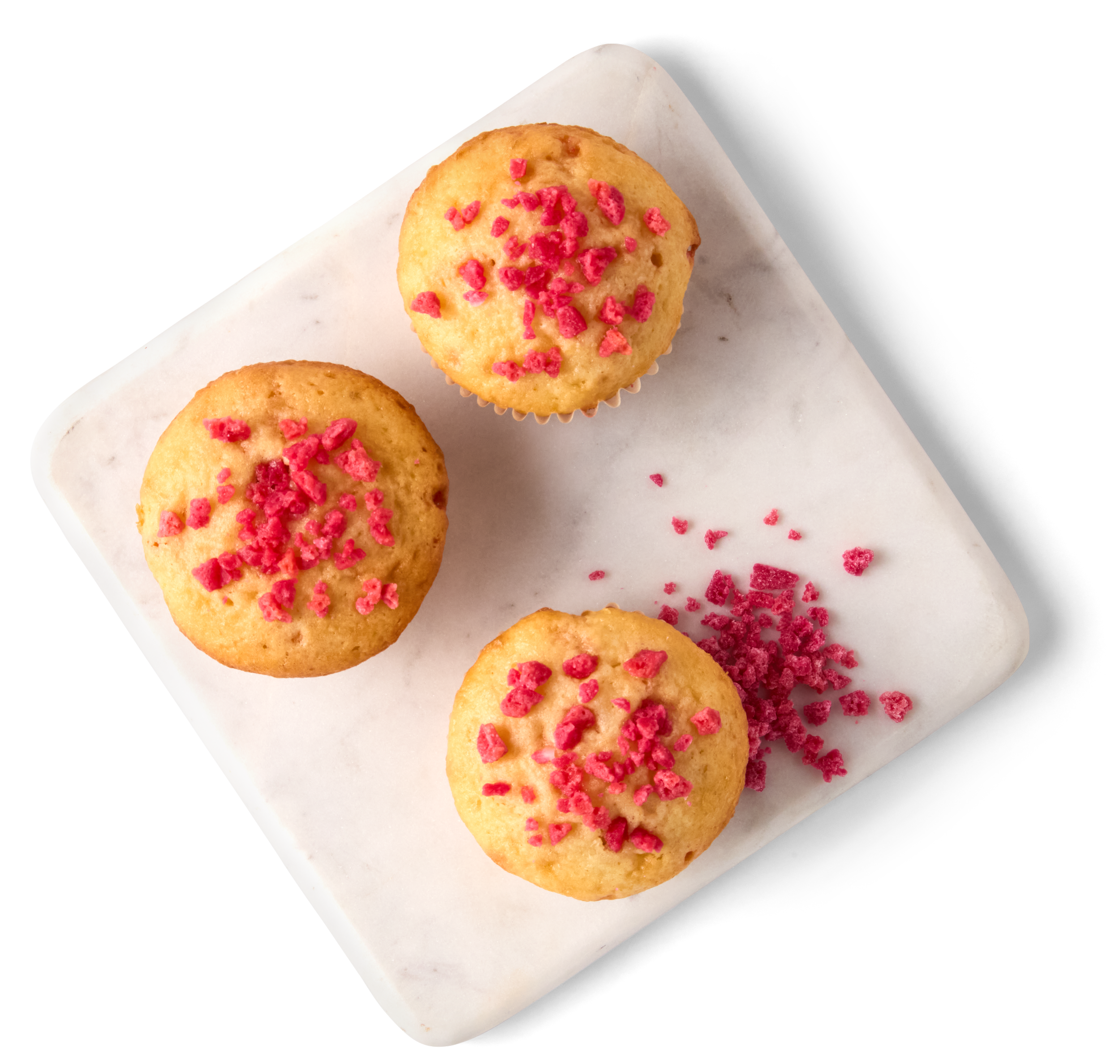 Three cupcakes with pink sprinkles on a white marble board, black background.