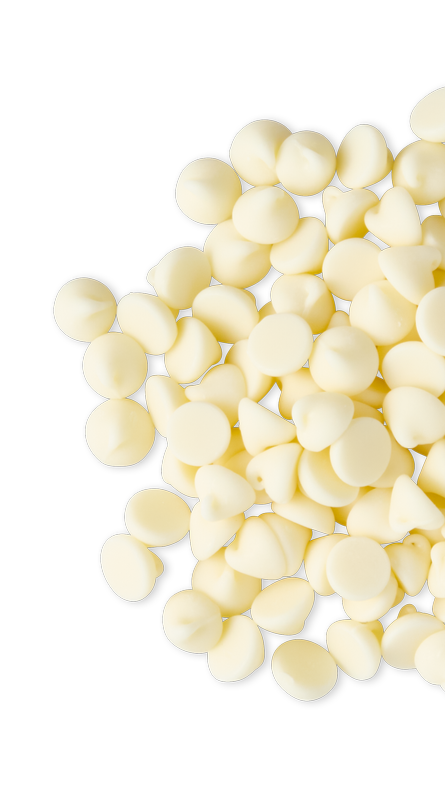 Close-up of small white chocolate chips scattered on a black background.