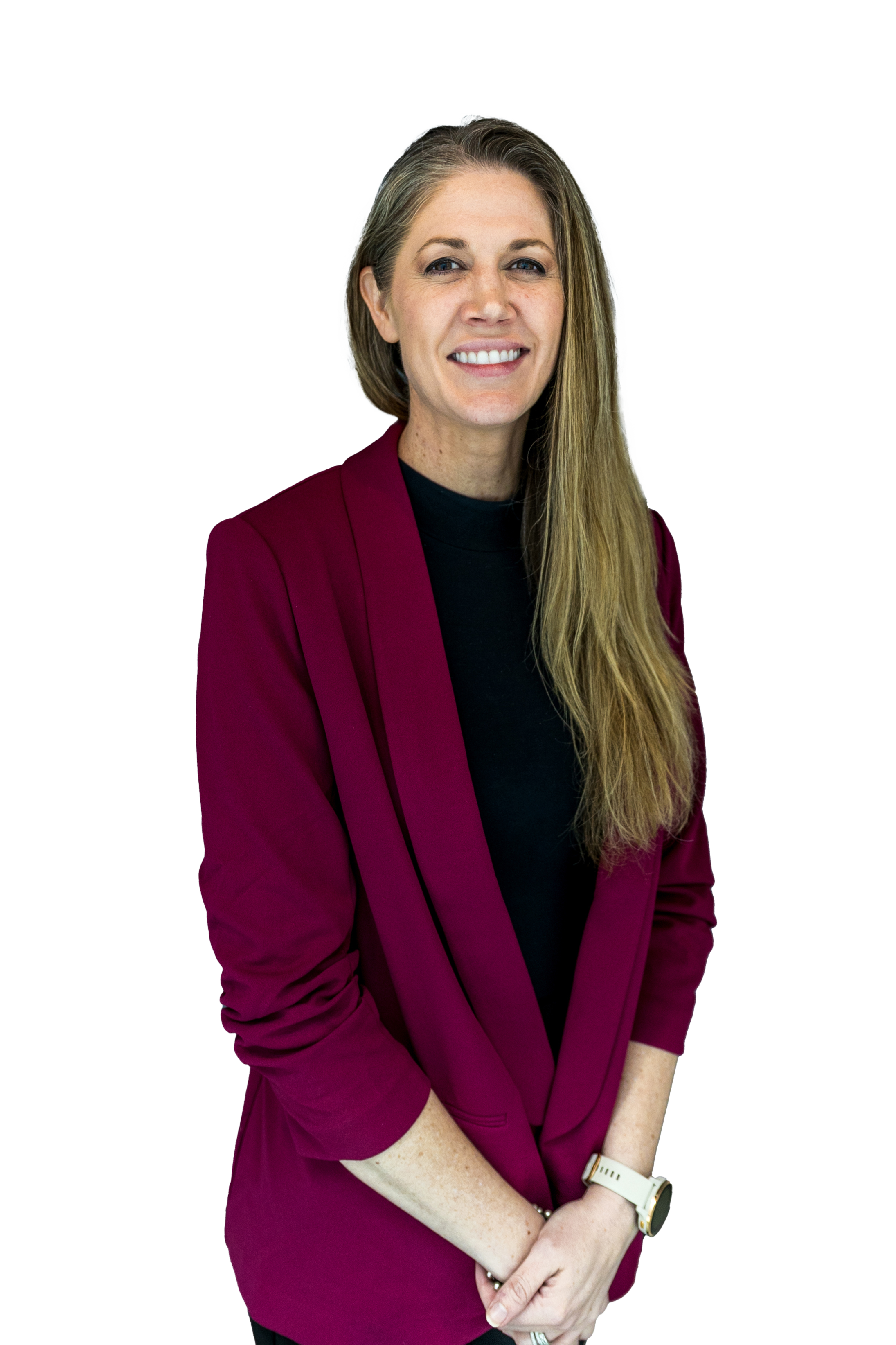 A woman with long blonde hair, wearing a maroon blazer and a black shirt, smiling and standing with her arms crossed, wearing a white watch on her left wrist.