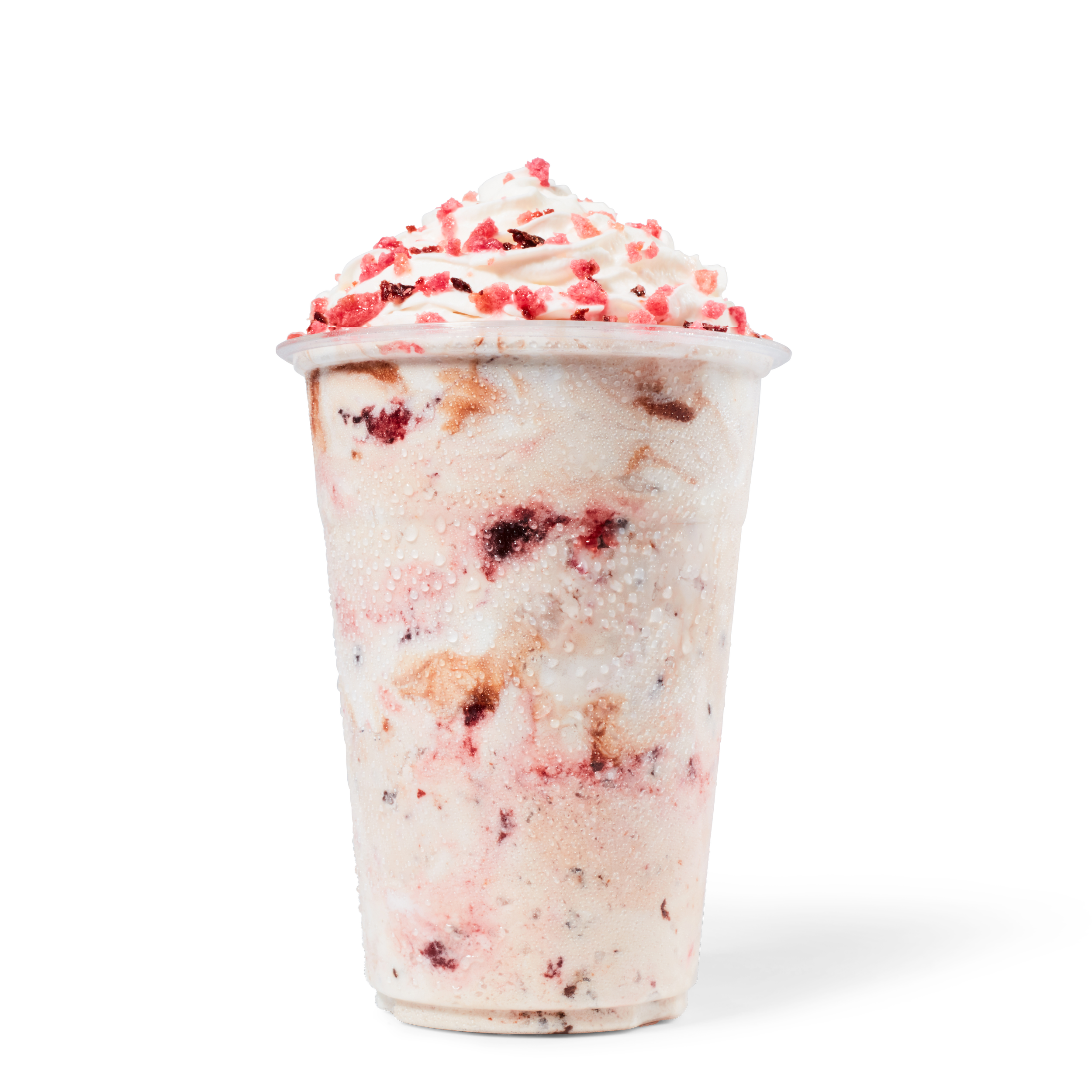 A cold beverage in a clear cup filled with ice cream, topped with whipped cream and red sprinkles, with condensation on the outside of the cup.